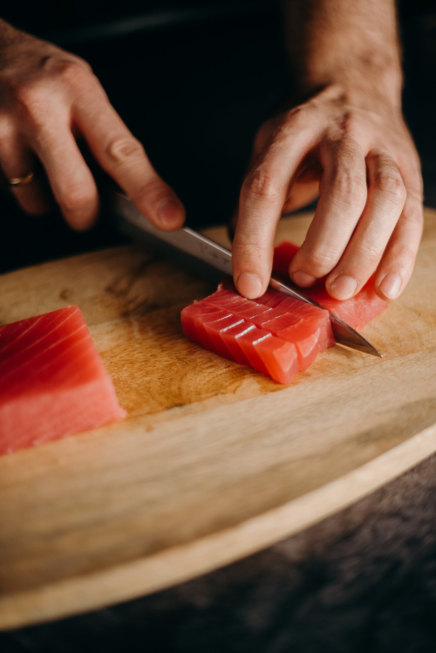 Fresh salmon being sliced on a chopping board.