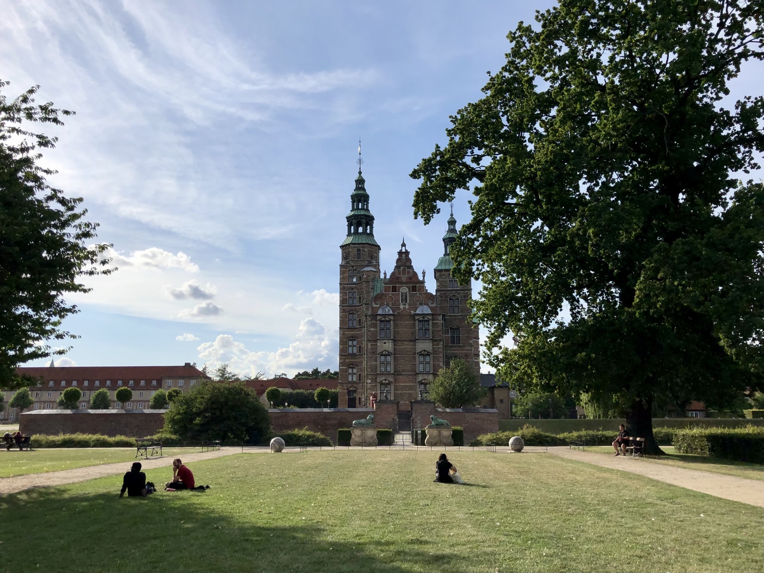 People relaxing on the lawn of Rosenborg Castle, Øster Voldgade, Copenhagen, Denmark.