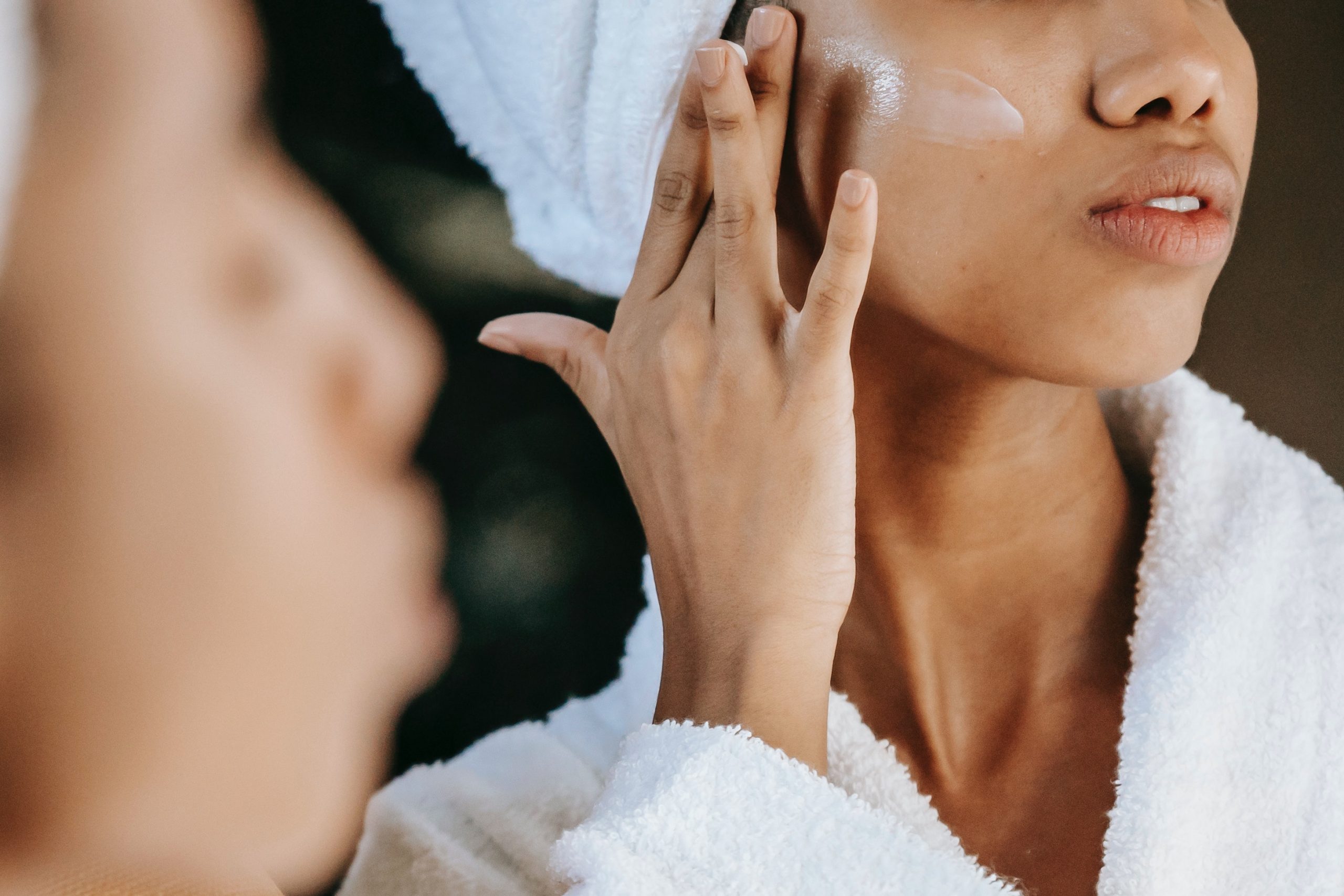 A woman applying oils to her face.