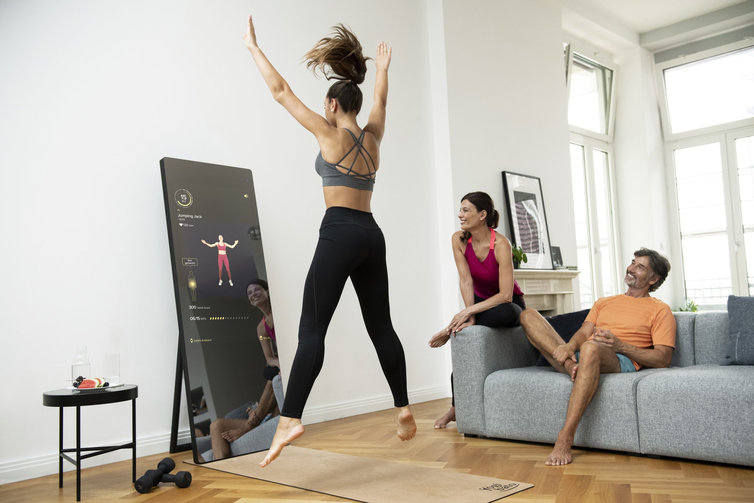 A woman trains in her living room using a VAHA interactive workout mirror with artificial intelligence 