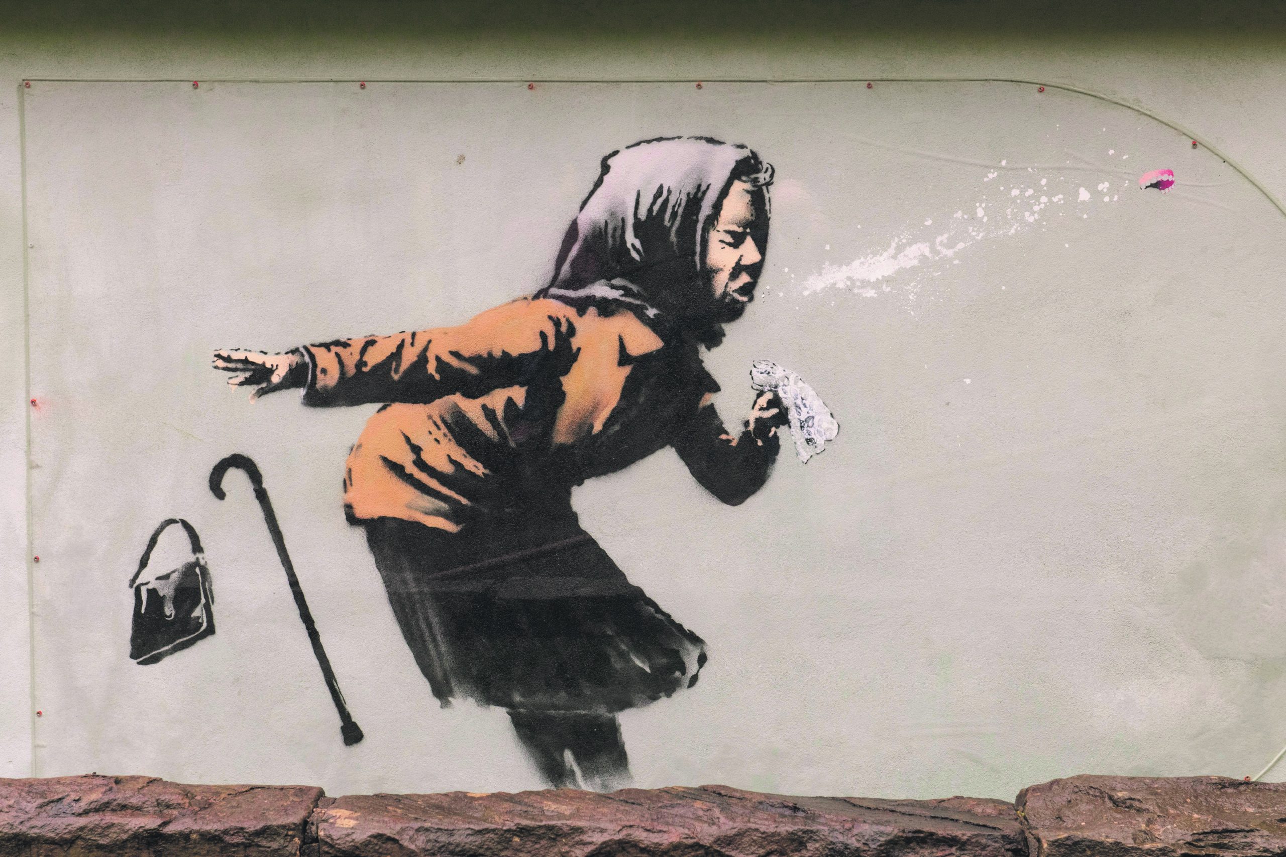 Banksy's mural of a woman sneezing, her cane and bag cast aside by the force of the sneeze