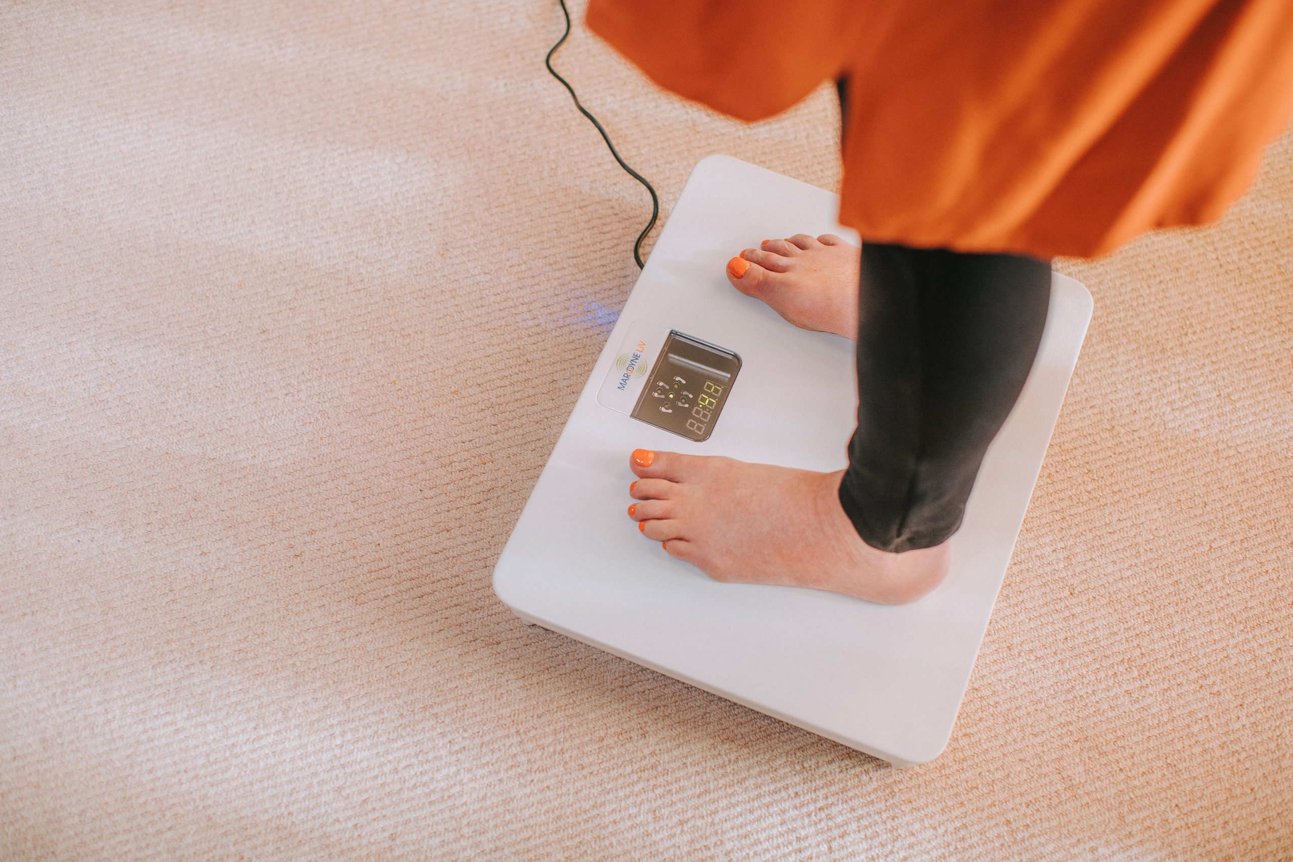 A bare-footed woman standing on the Marodyne LiV for 10 minutes to reduce osteoporosis 