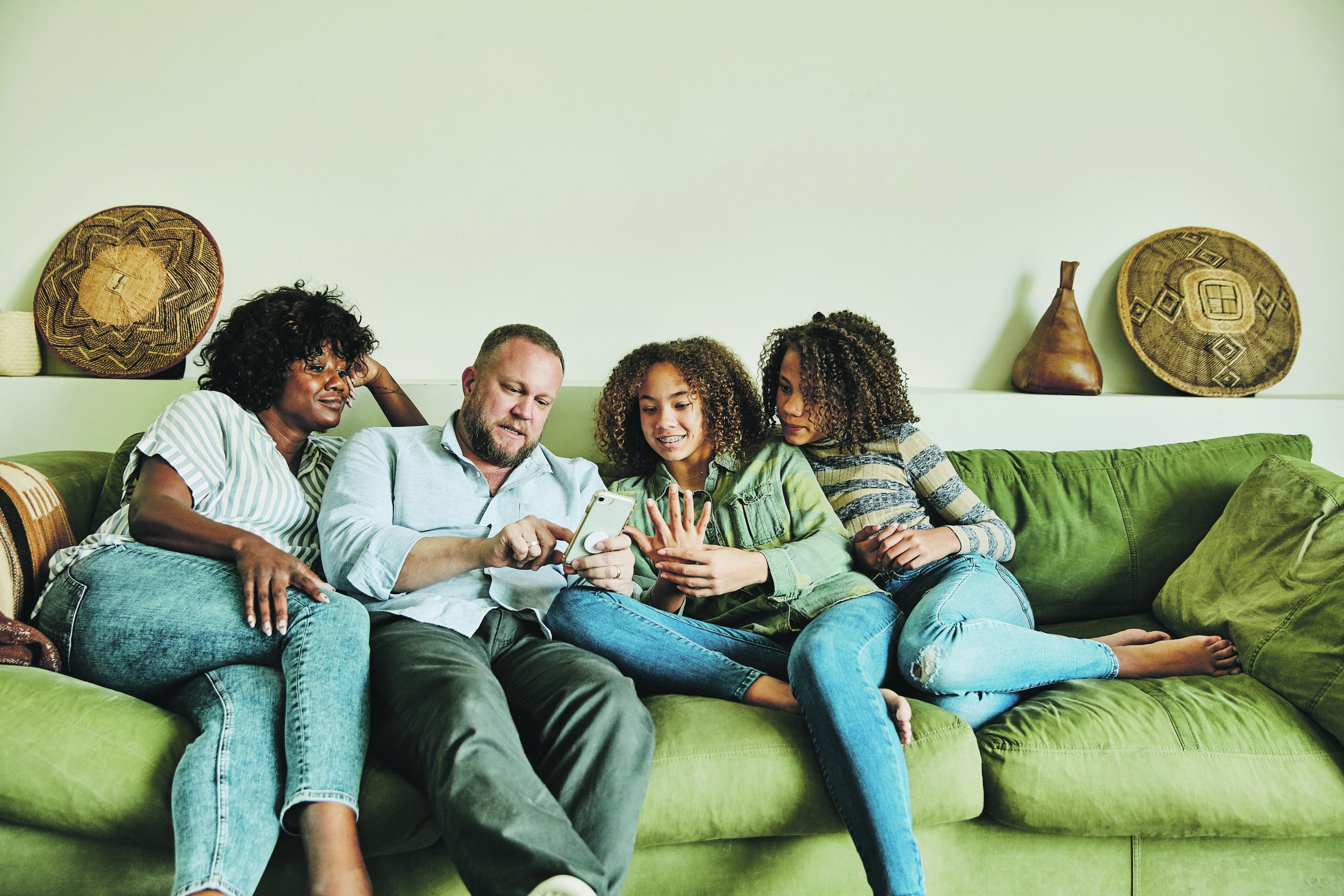 On the sofa a family work out their finances with the kids listening in.