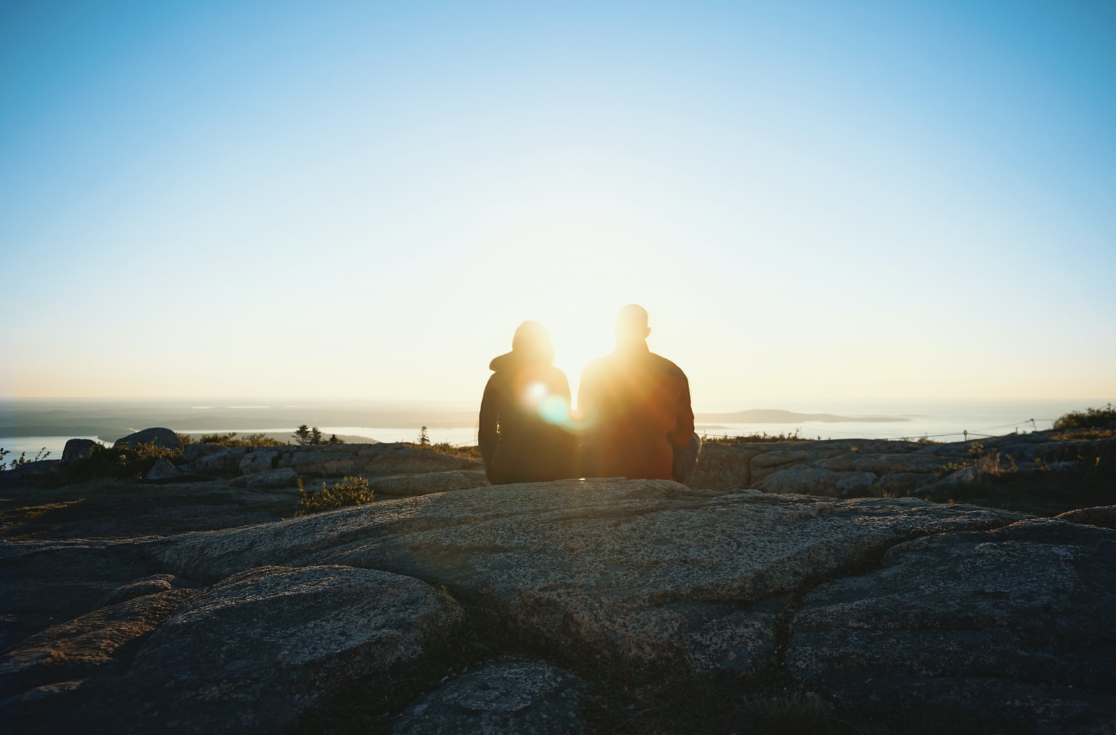 A couple talk through their issues as the sun sets over the sea.