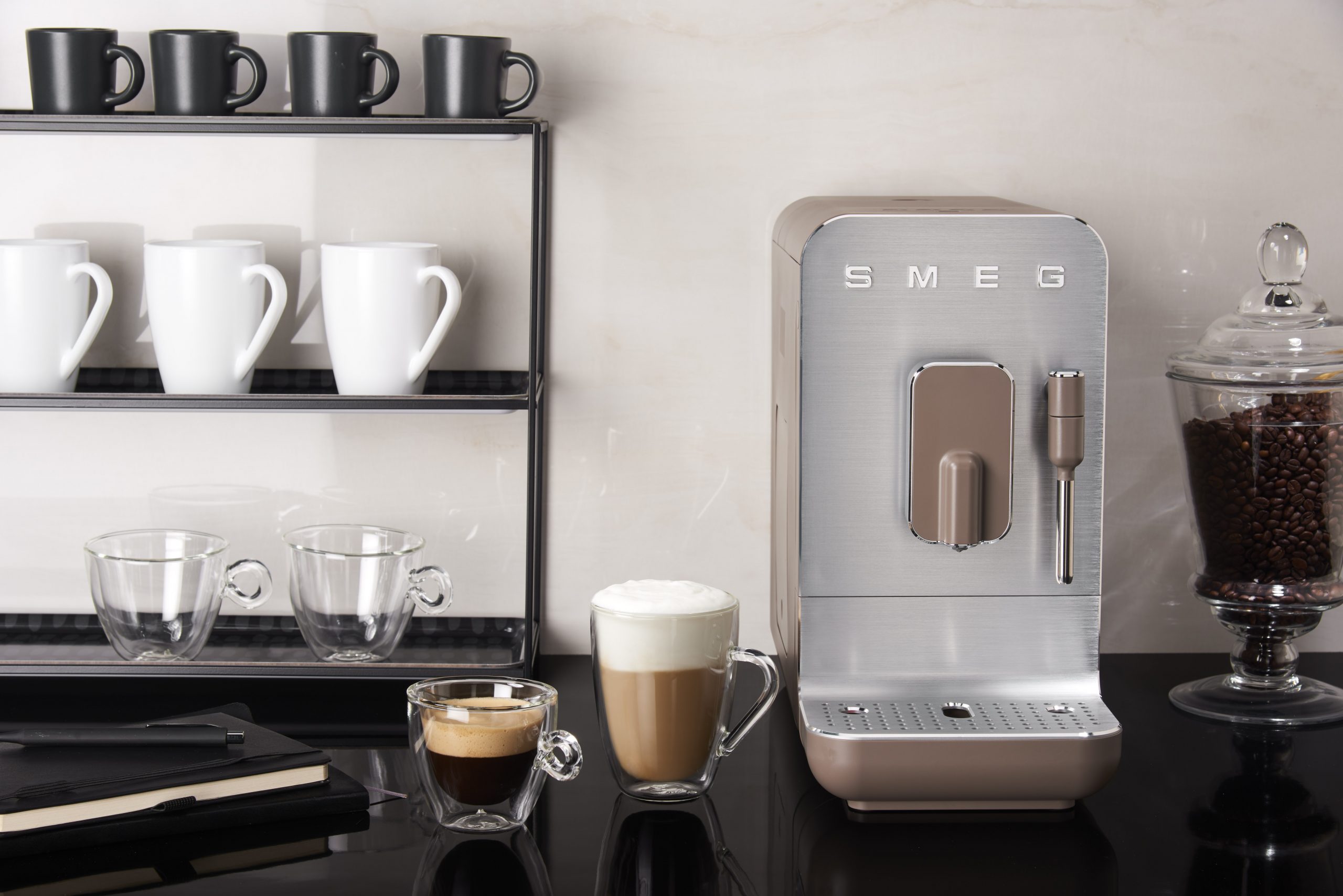 On a kitchen worktop, a Smeg Coffee Machine showcases the drinks it can make.