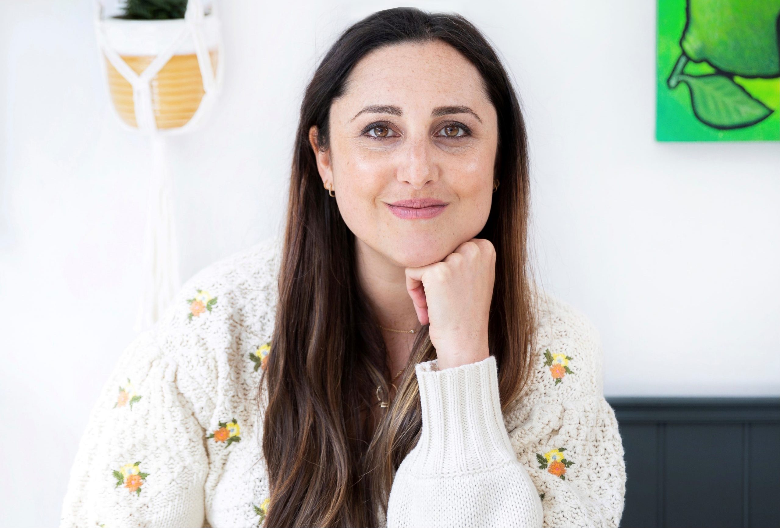 A portrait of Emma Hollingsworth, baking blogger and author, smiling face on, resting her hand on her chin