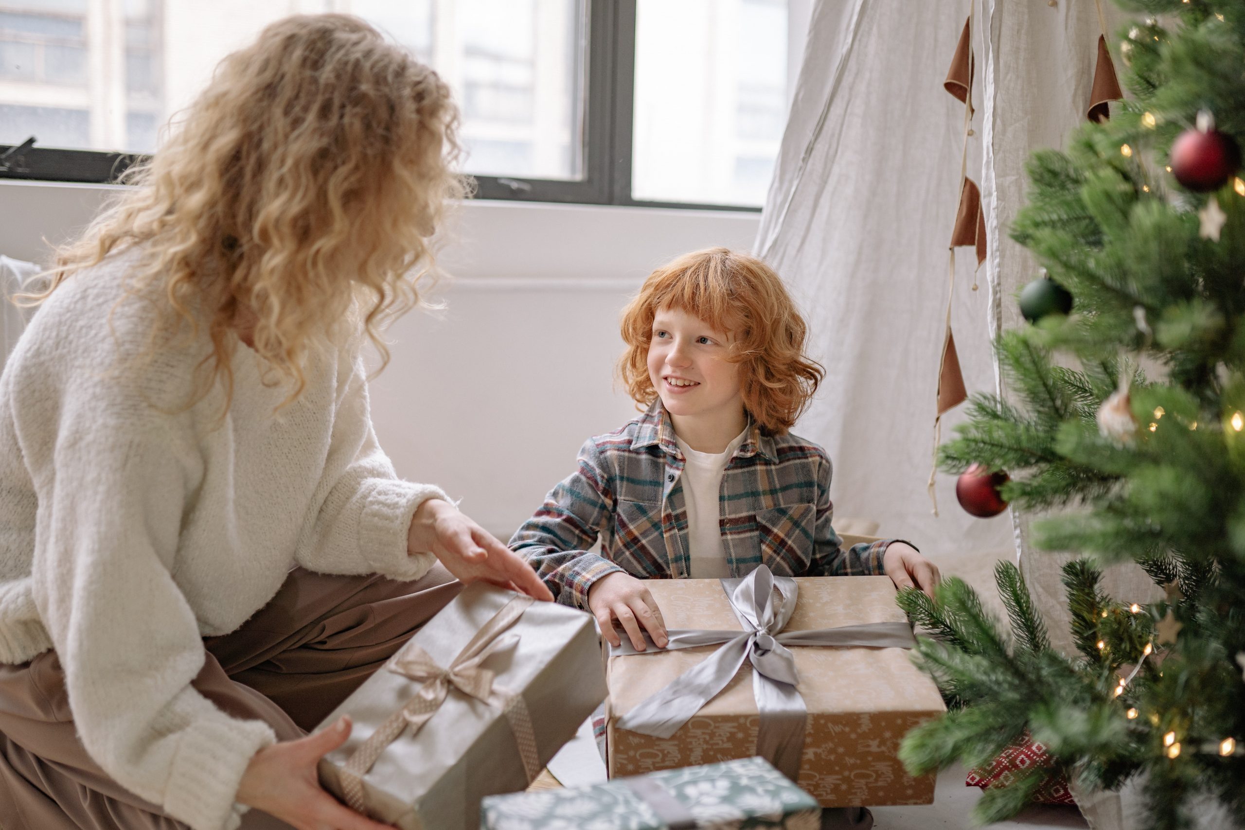 A child receives a Christmas present through the donate a gift scheme run by charities