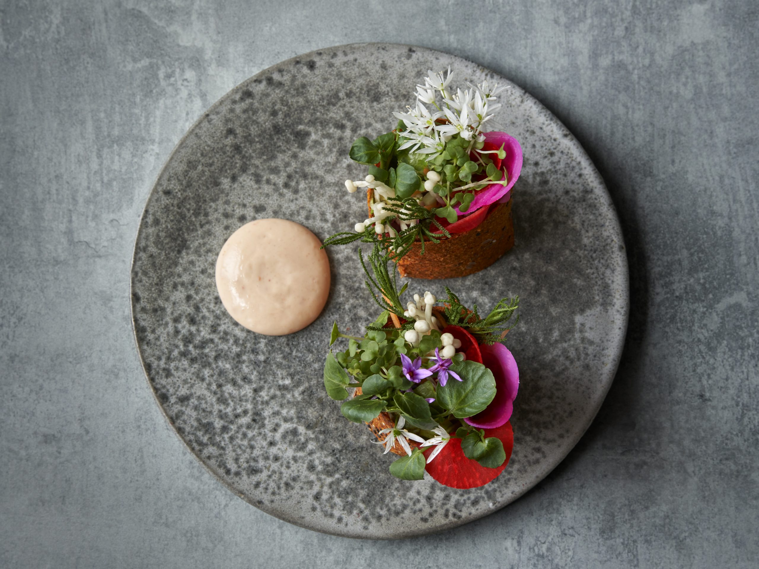 A beautifully presented red pepper burrito on a grey plate from Holy Carrot in Knightsbridge