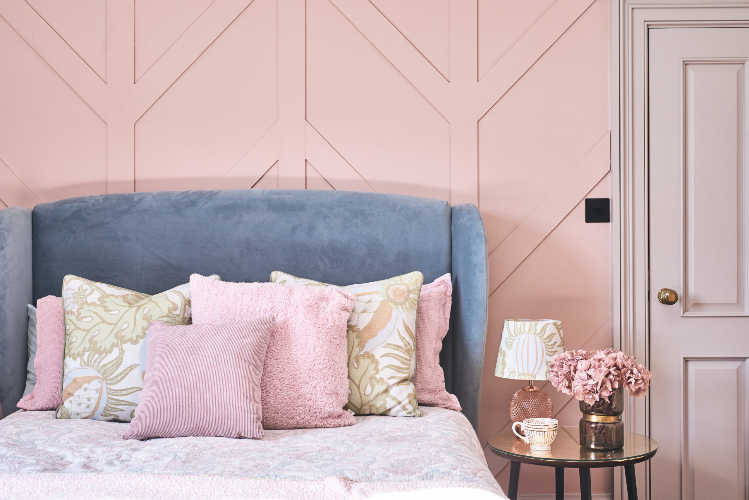 A guest bedroom featuring modern chevron-design panelling.