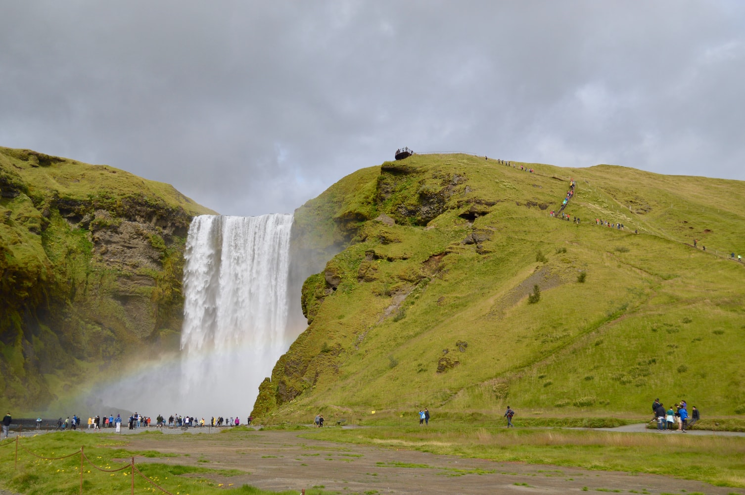 The majesty of Skogafoss Waterfall as crowds look on.