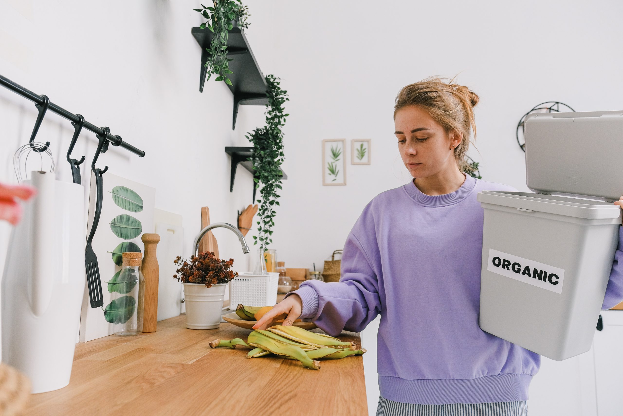 A woman recycles banana skins from her kitchen worktop.