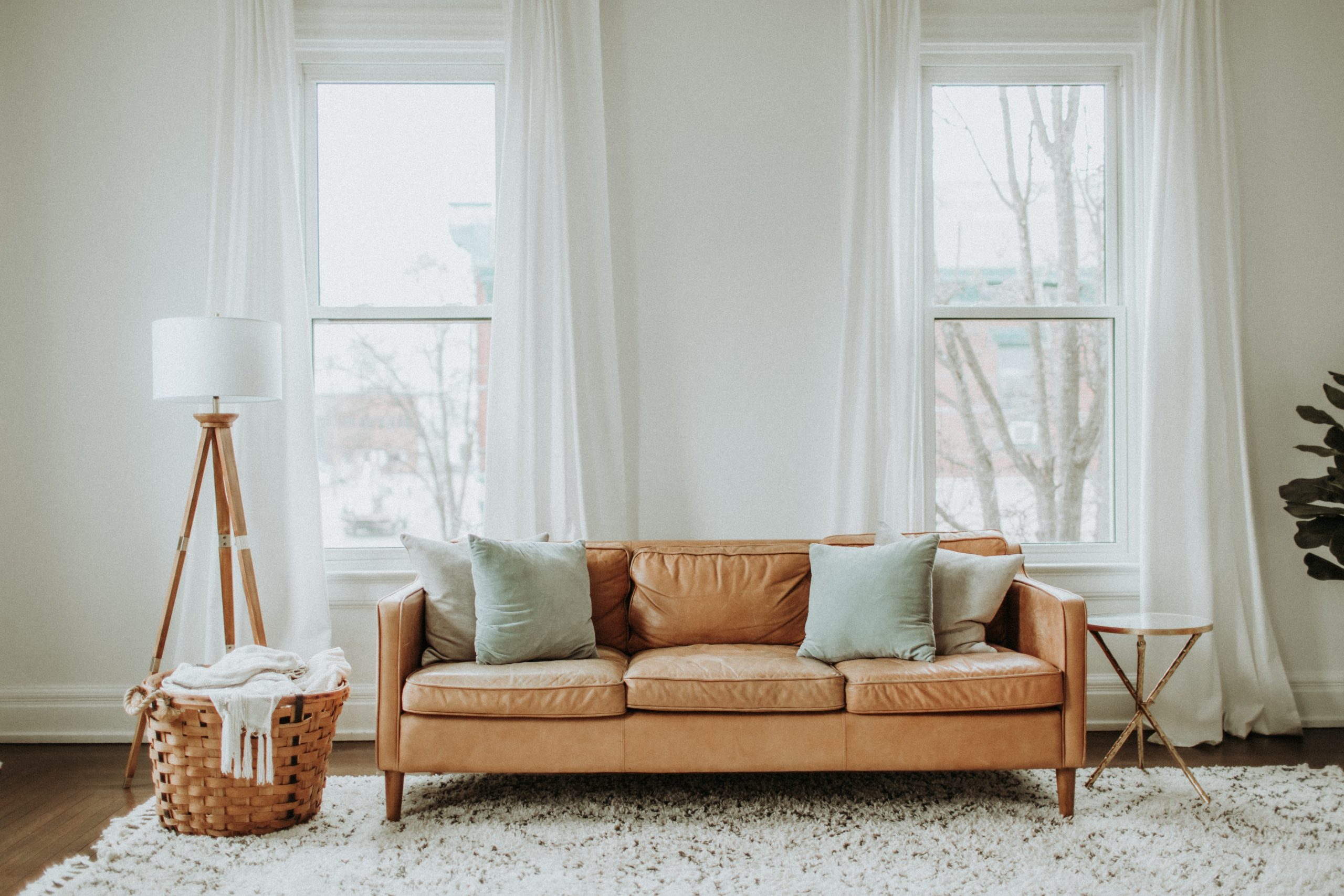 A leather sofa in a living room upcycled with new cushions and legs.