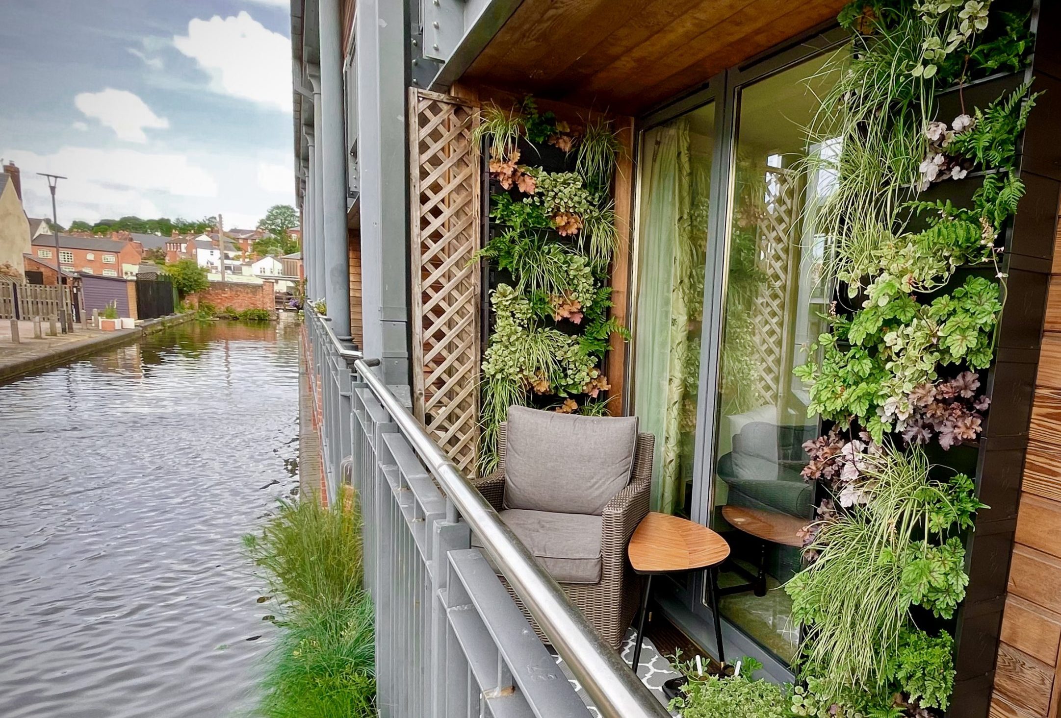 A living wall on the balcony of an apartment overlooking a river.