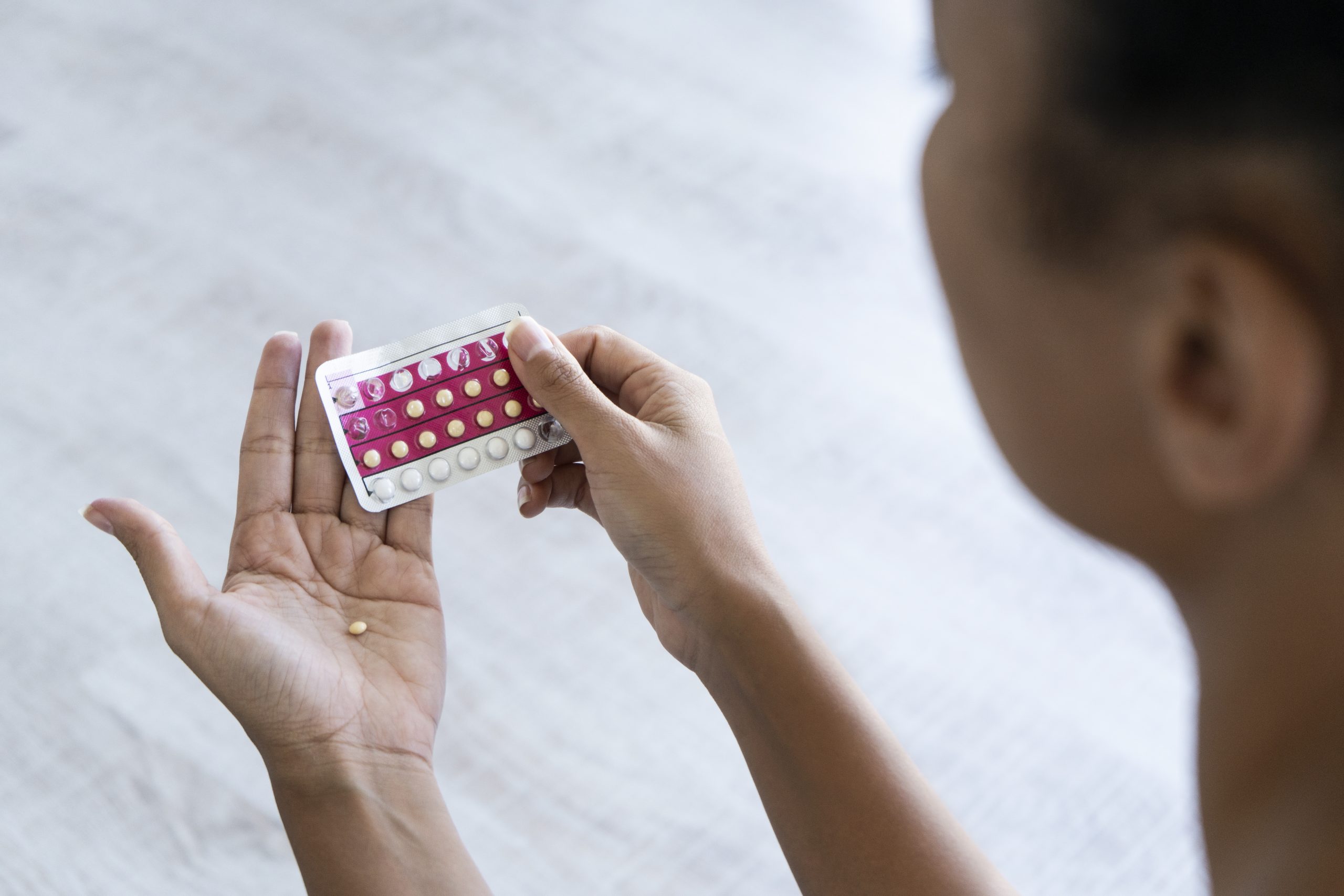 A woman prepares to take a birth control pill