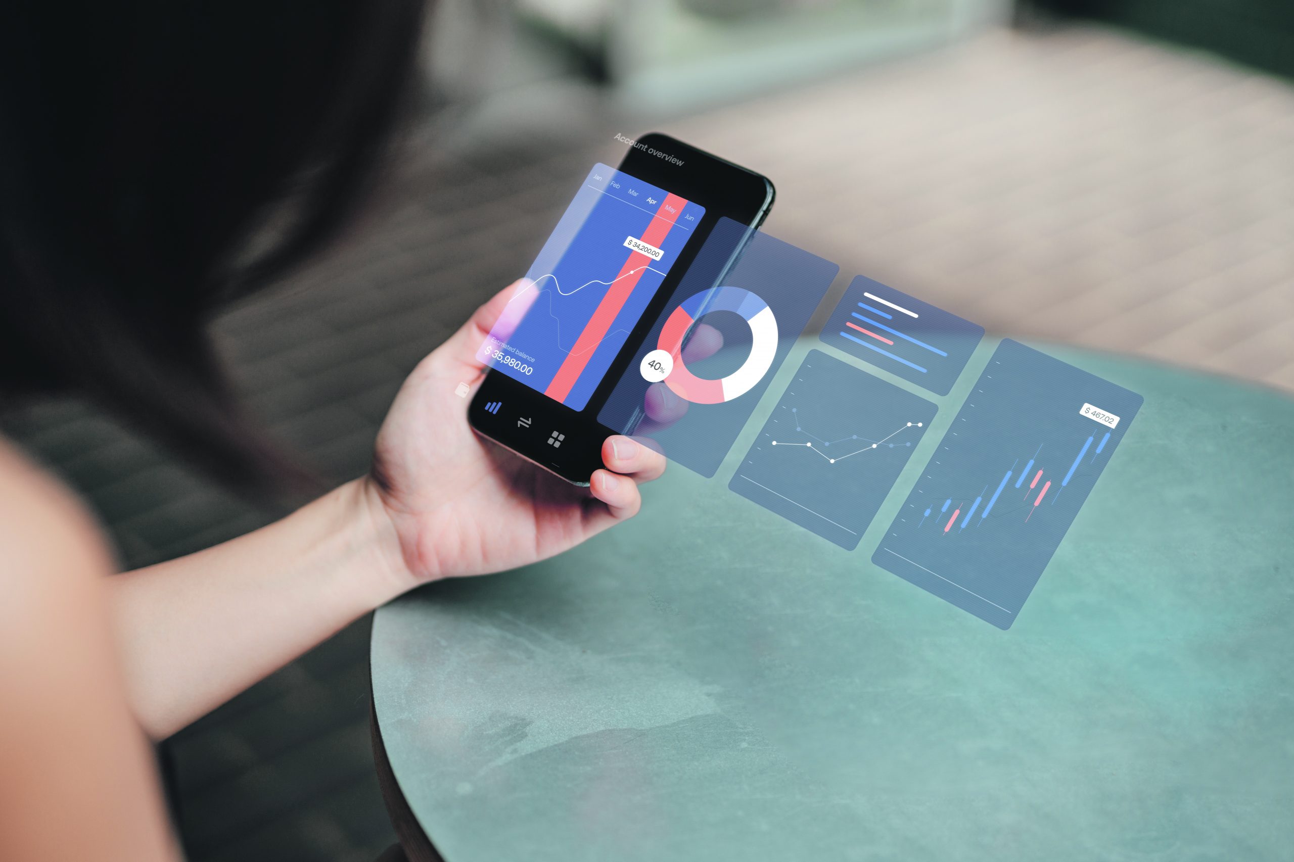 Closeup of a young businesswoman analysing finance data on her smartphone with virtual reality technology. Stock exchange market trading board in background. Blockchain concept. Cryptocurrency market.