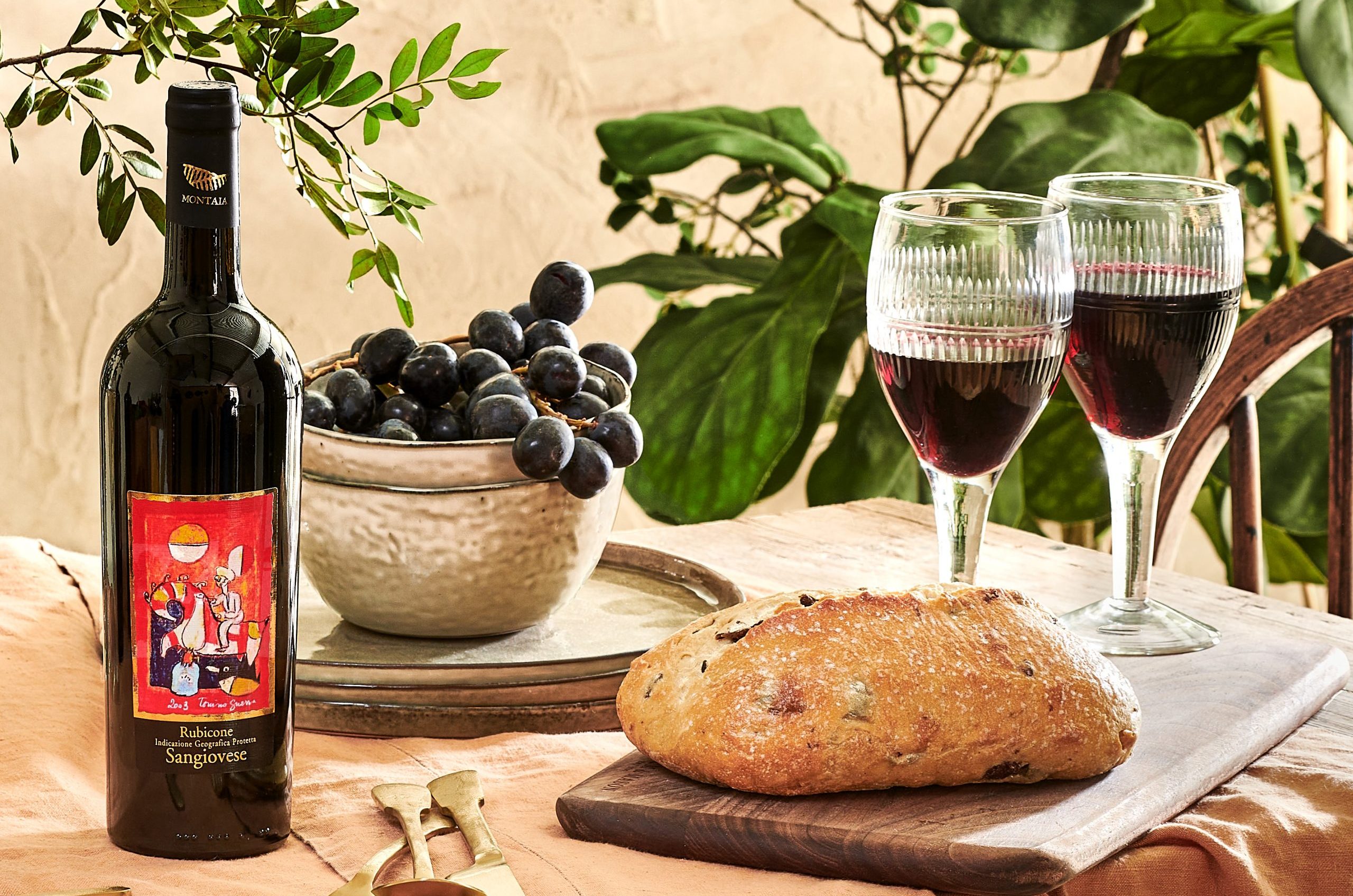 Wickhams' ‘The Garden of Italy’ wine showcased next to wine glasses, fresh baked bread and grapes.