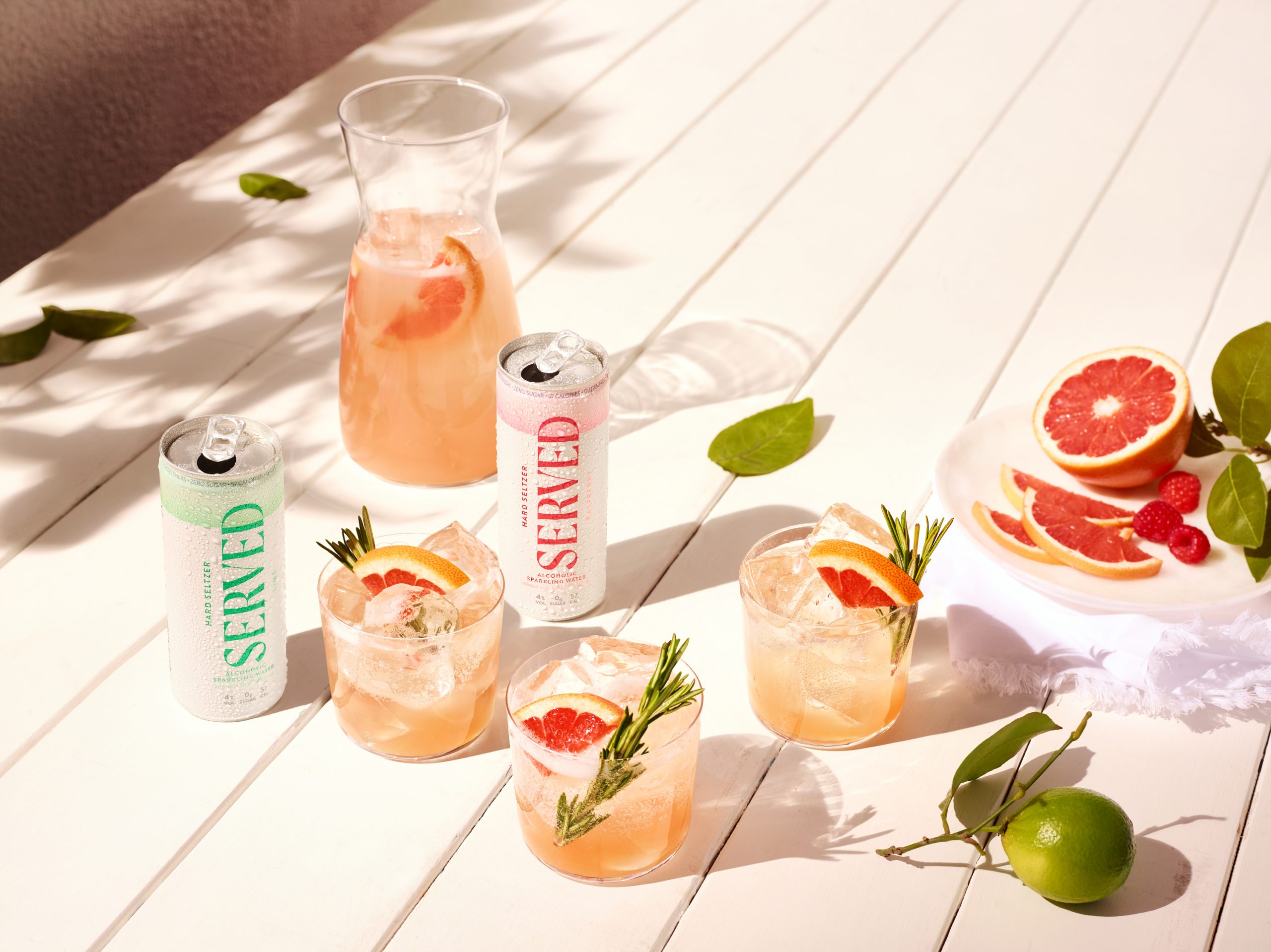 Two Served canned cocktails served with ice and slices of blood orange on a summer's day.