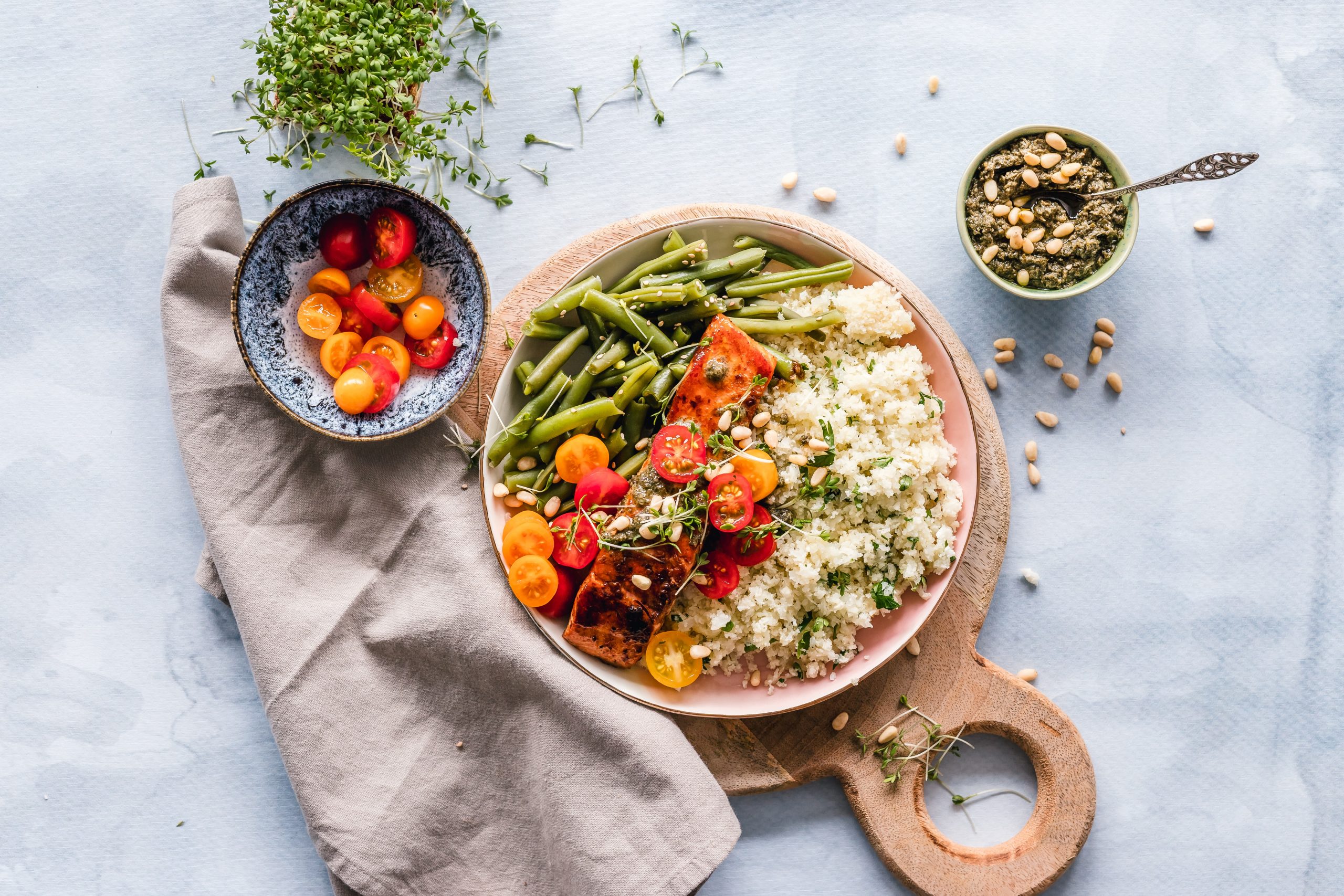 A plate of salmon, green beans and rice served with tomato salad.