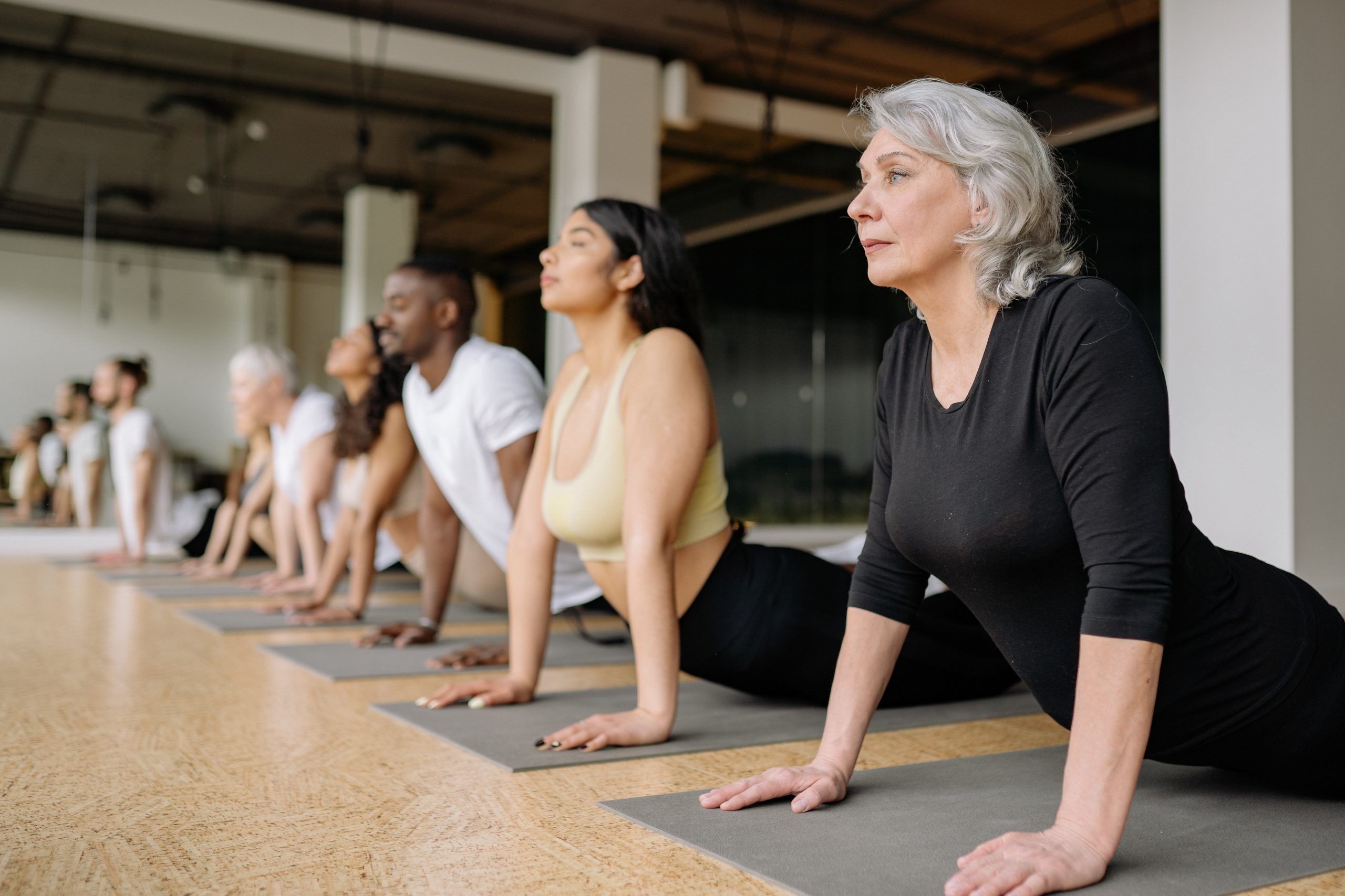 A class of mixed ages and backgrounds taking a yoga class.