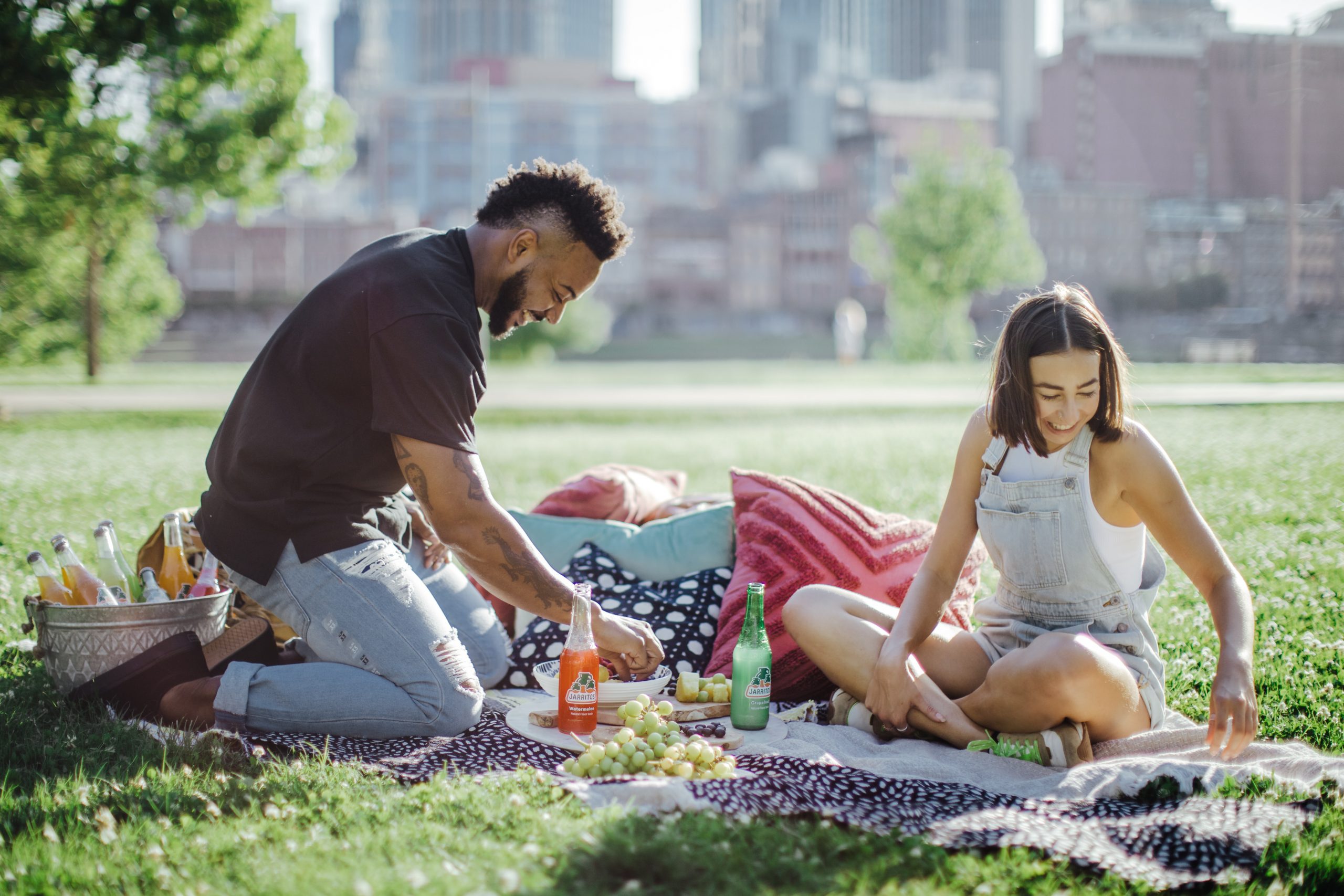 A happy couple picnicking with two bottles of Green Man Woodland Gin.