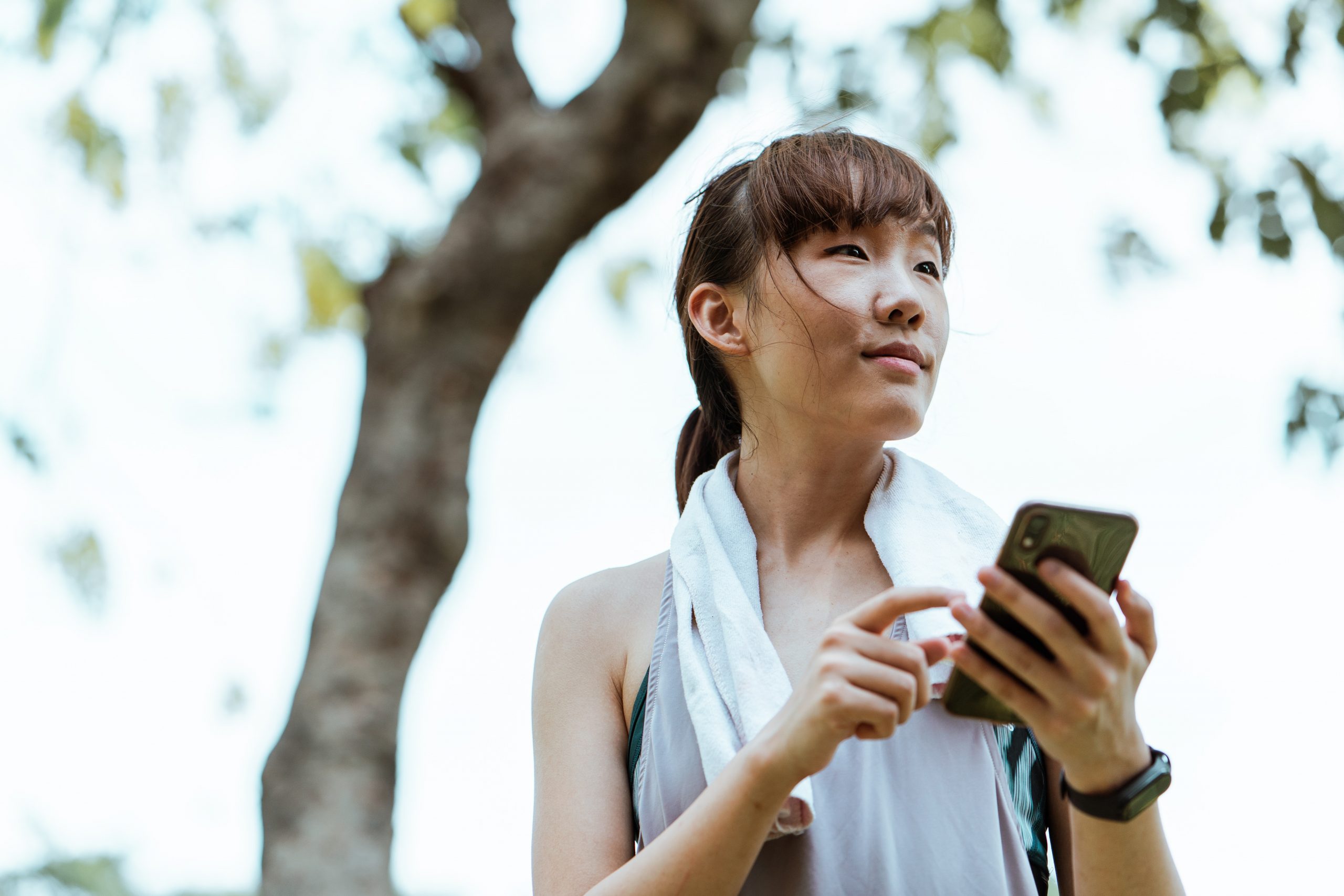 An Asian woman checking her smartphone.