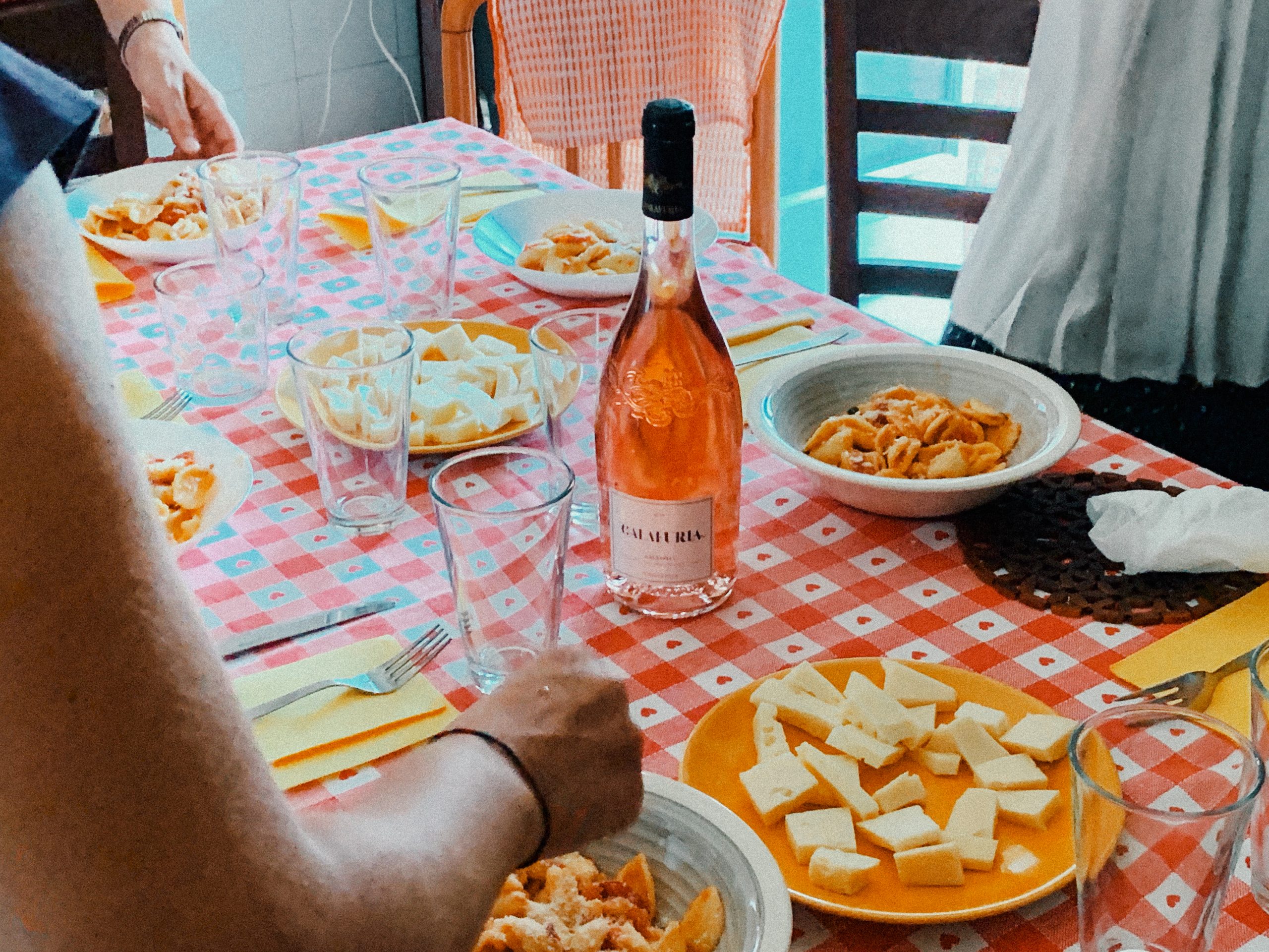 In the middle of a table with snacks laid out, a bottle of Italian rosé Calafuria.