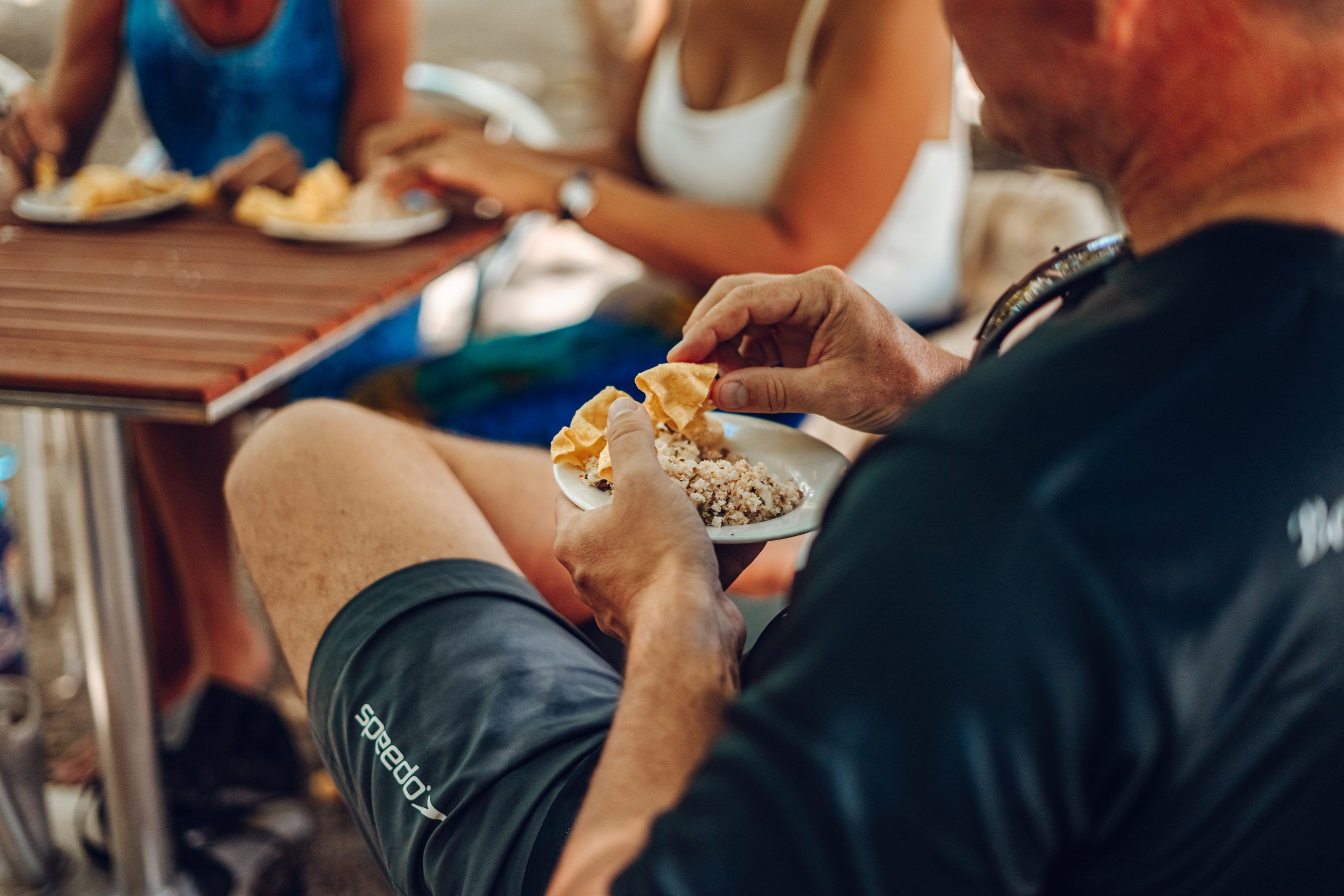 Out in the sun, three tourists sample the local delicacies in the Maldives.