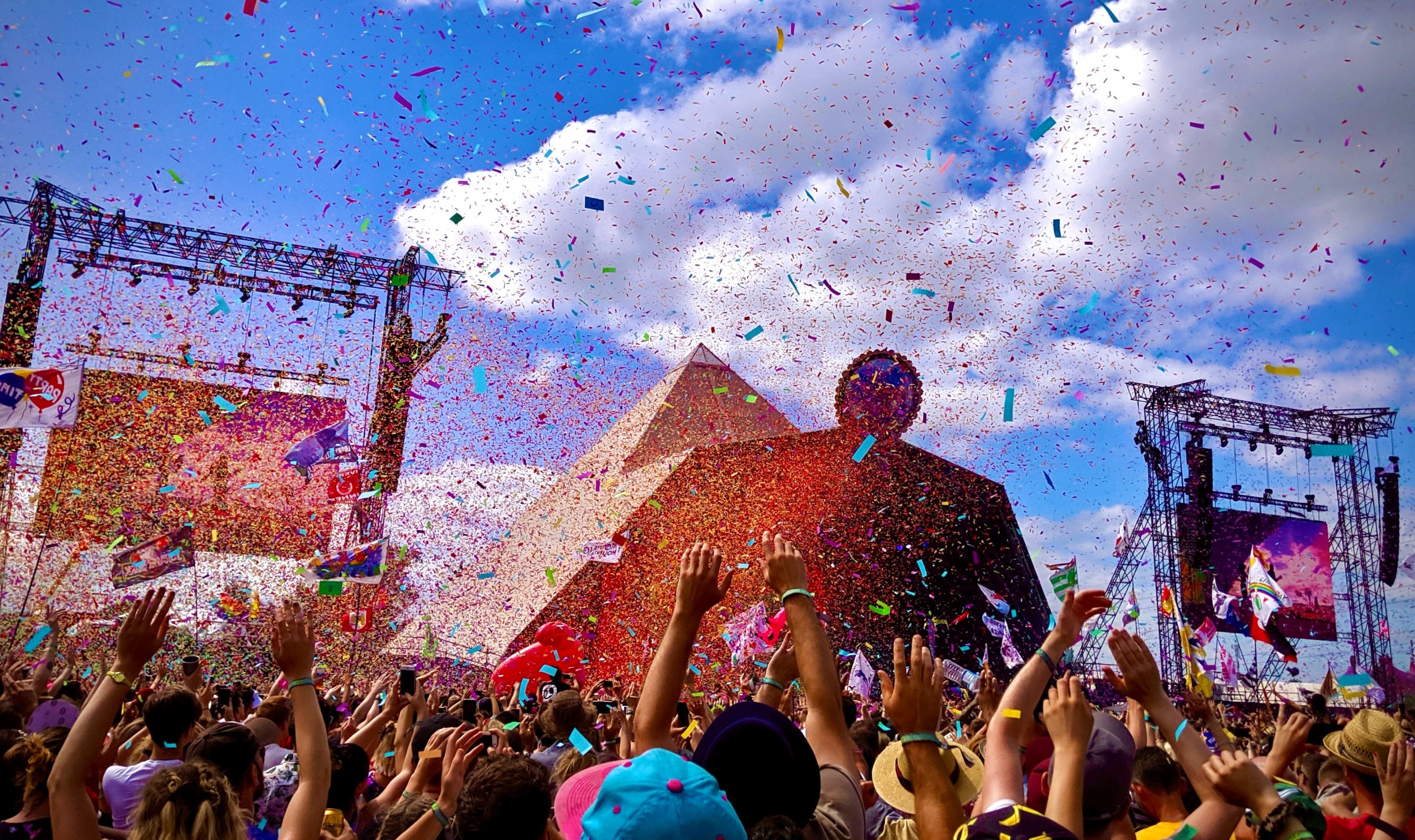 As confetti rains down, a crowd parties on during a Glastonbury concert.