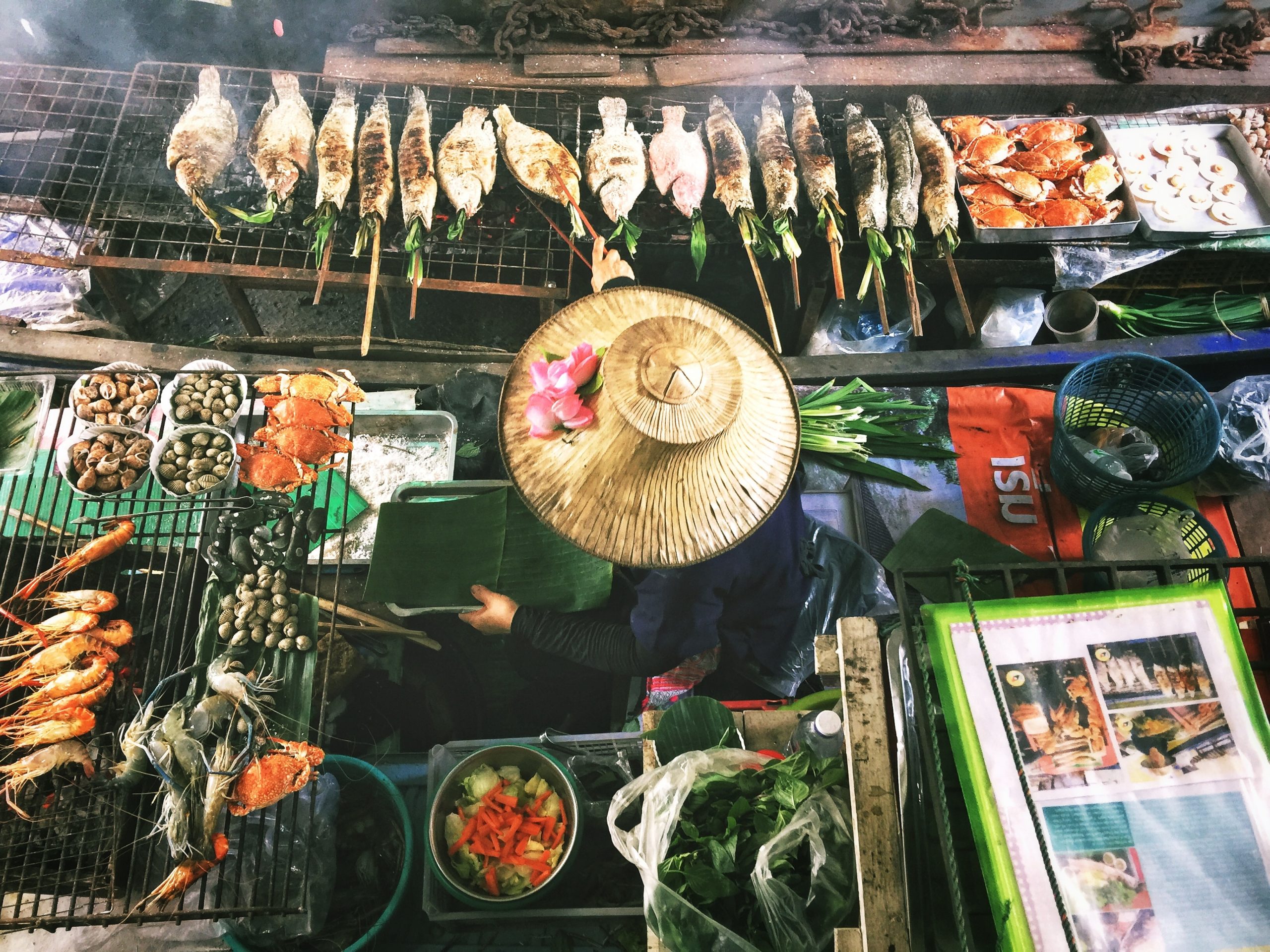 Aerial view of a Bangkok street food seller cooking a variety of fish.