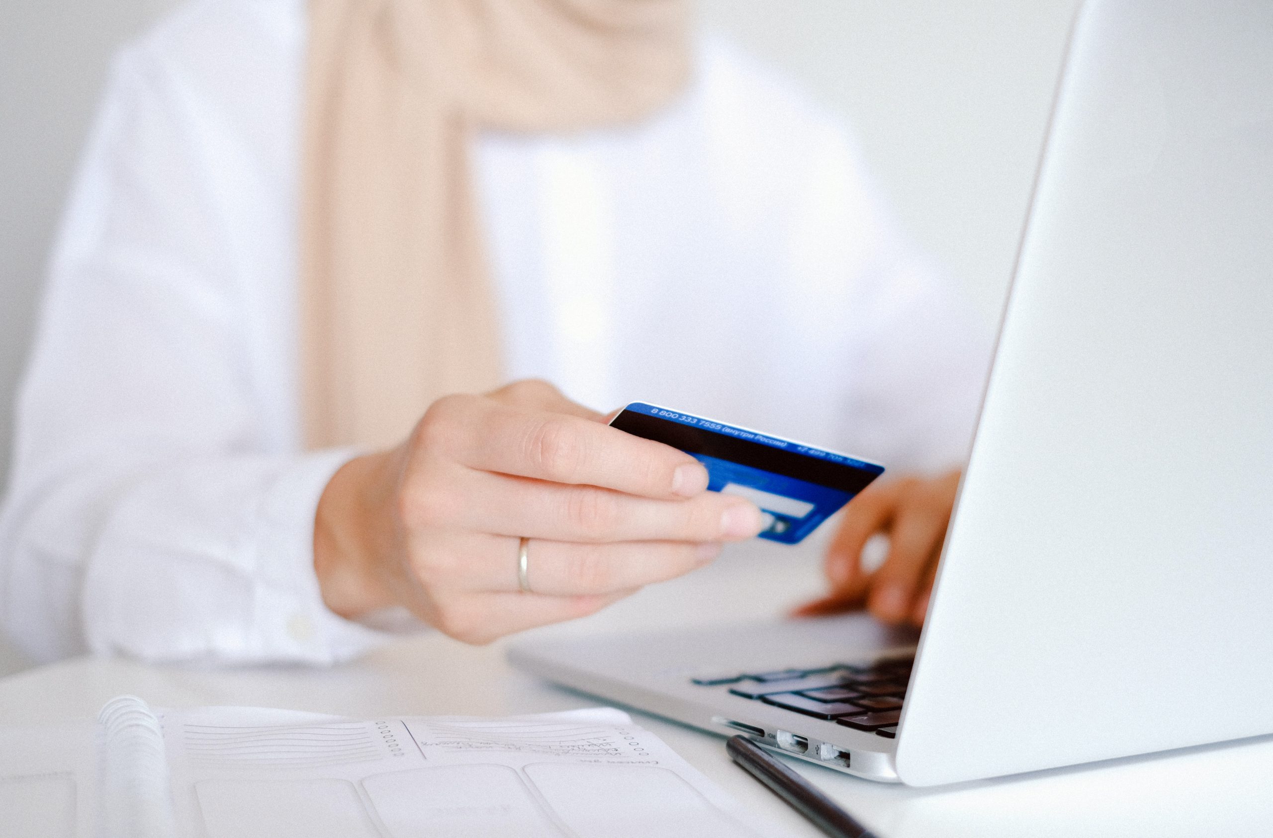 A woman making an online investment in Baird & Co. on her MacBook.