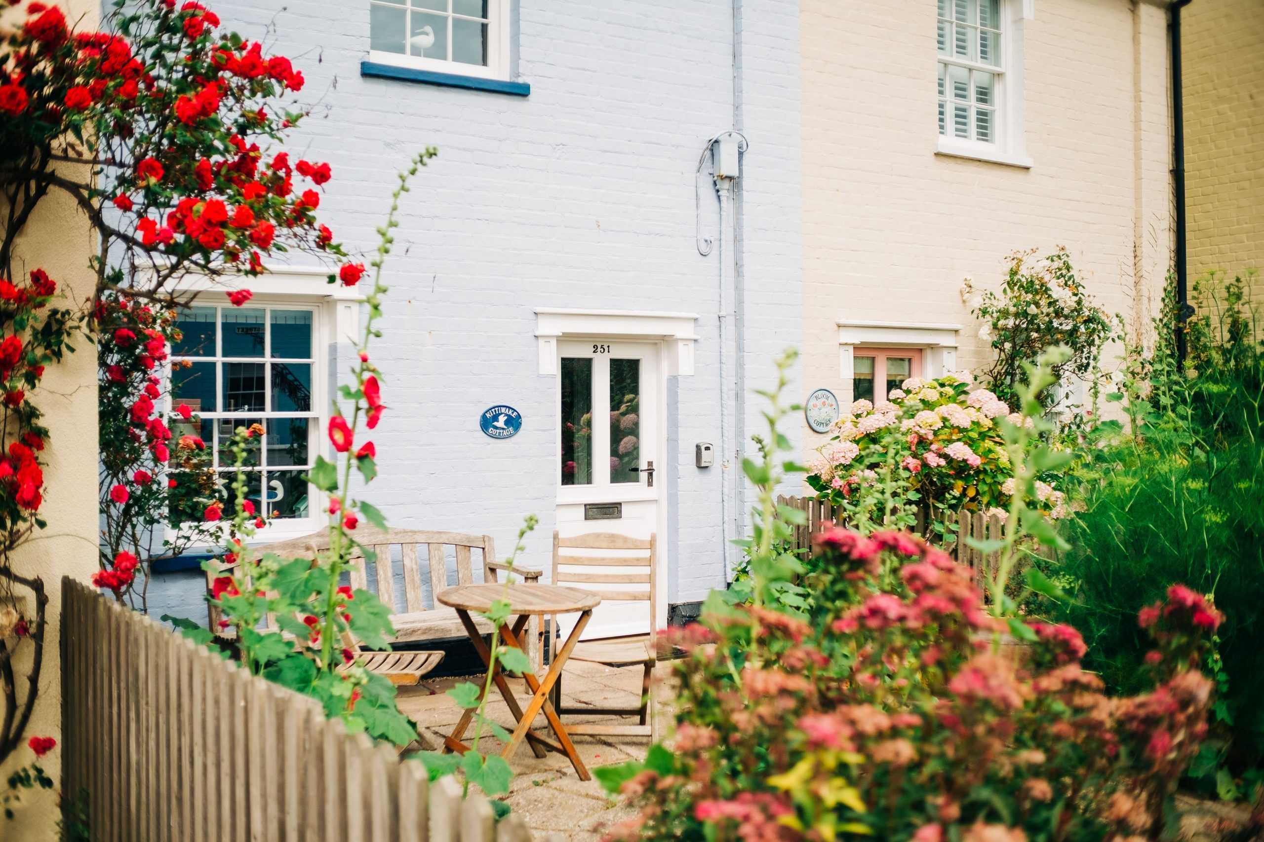 The charming front garden of a terraced English home blooming with flowers.