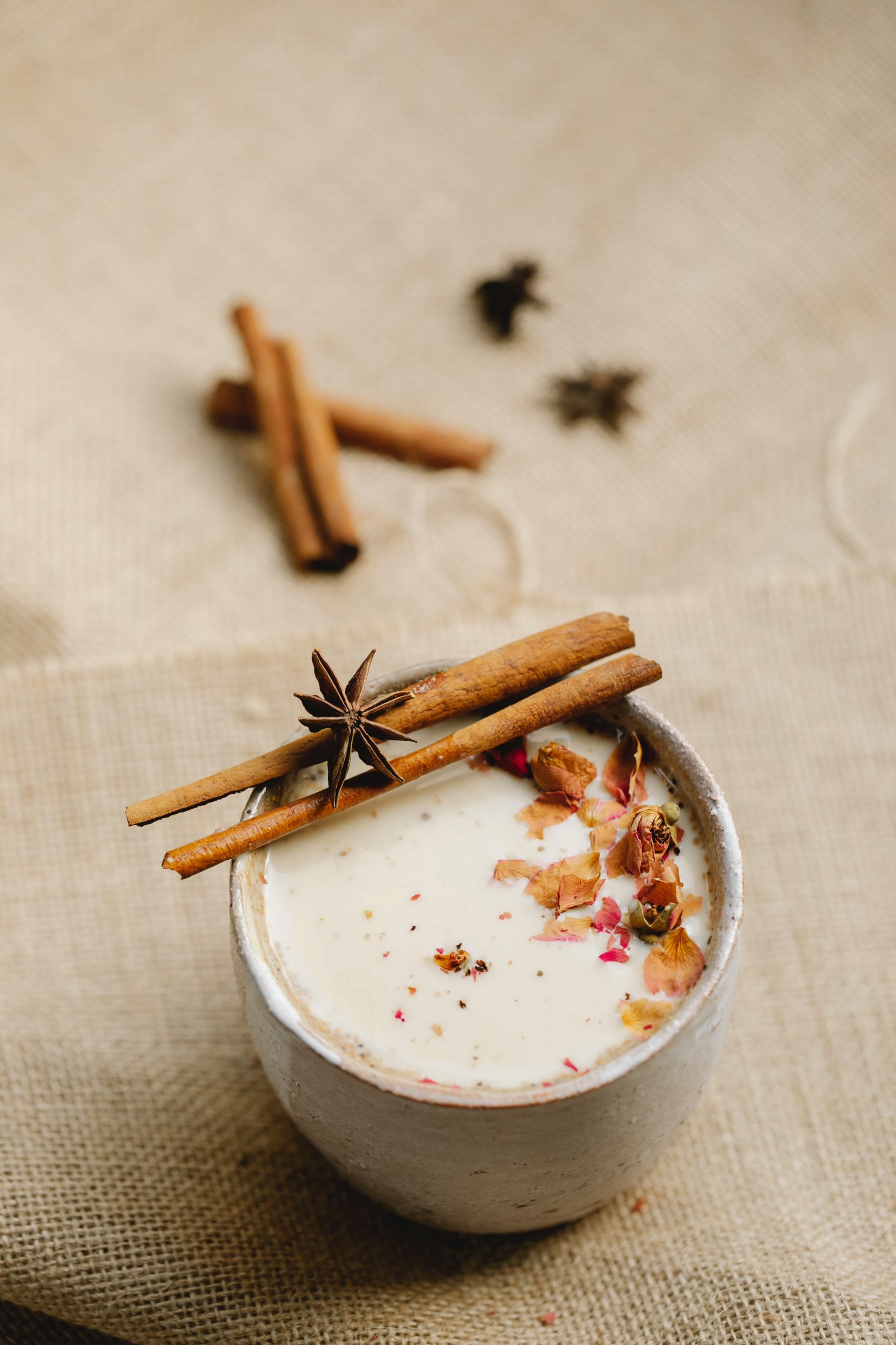 A cup of Chai tea with cinnamon and star anise on linen fabric.