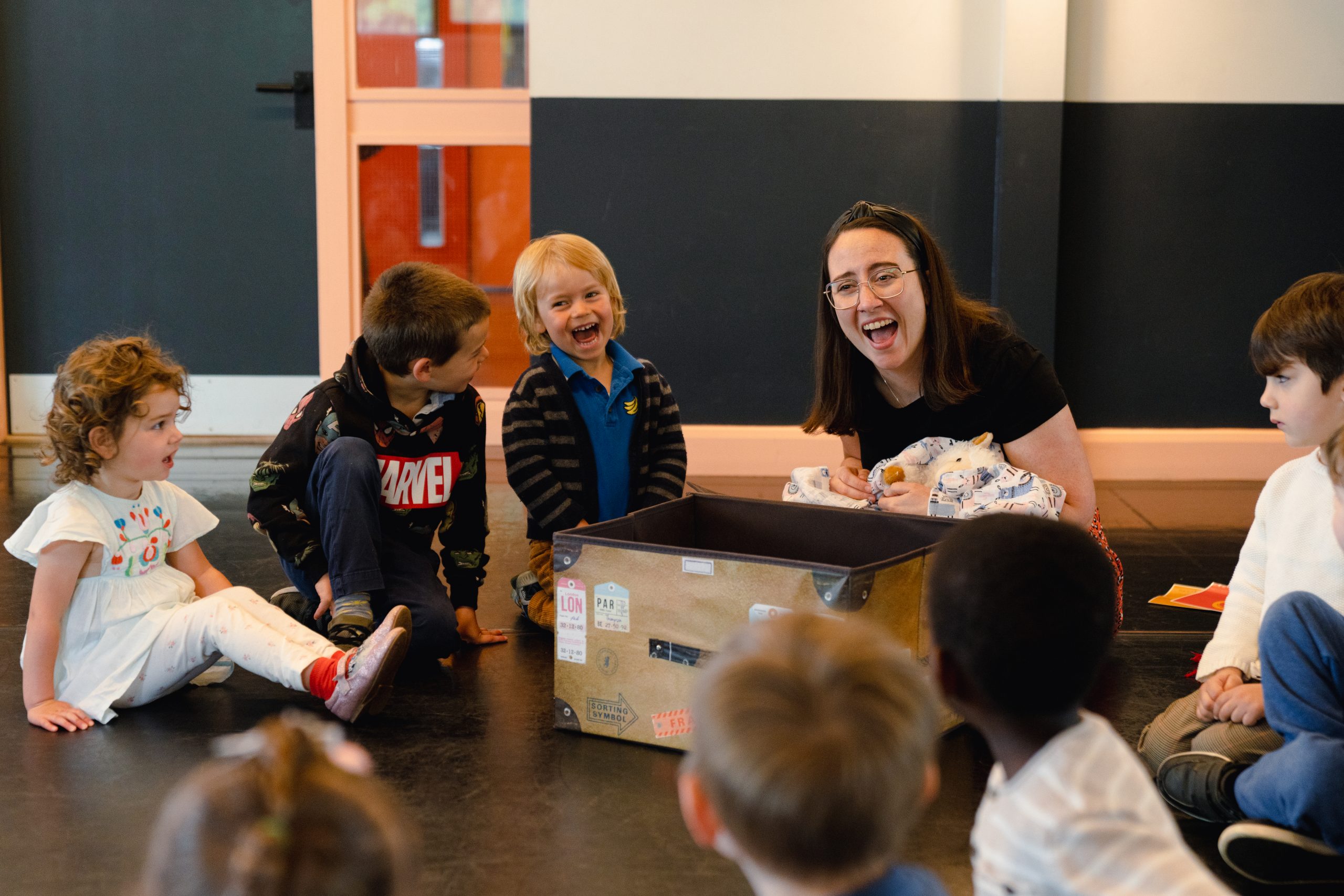 A class of young kids having fun learning a new language with their teacher.