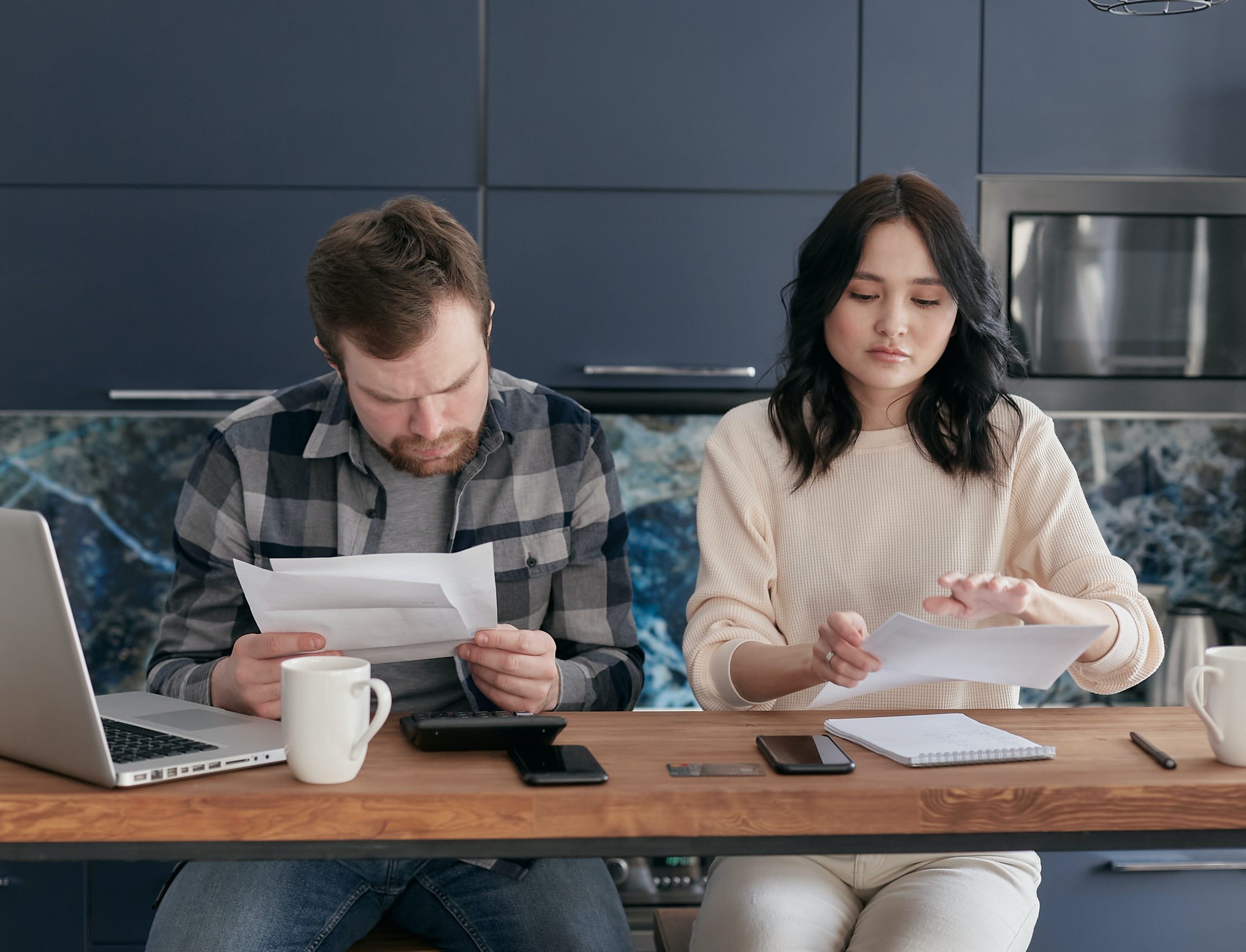 A couple sitting next to each other review their finances.