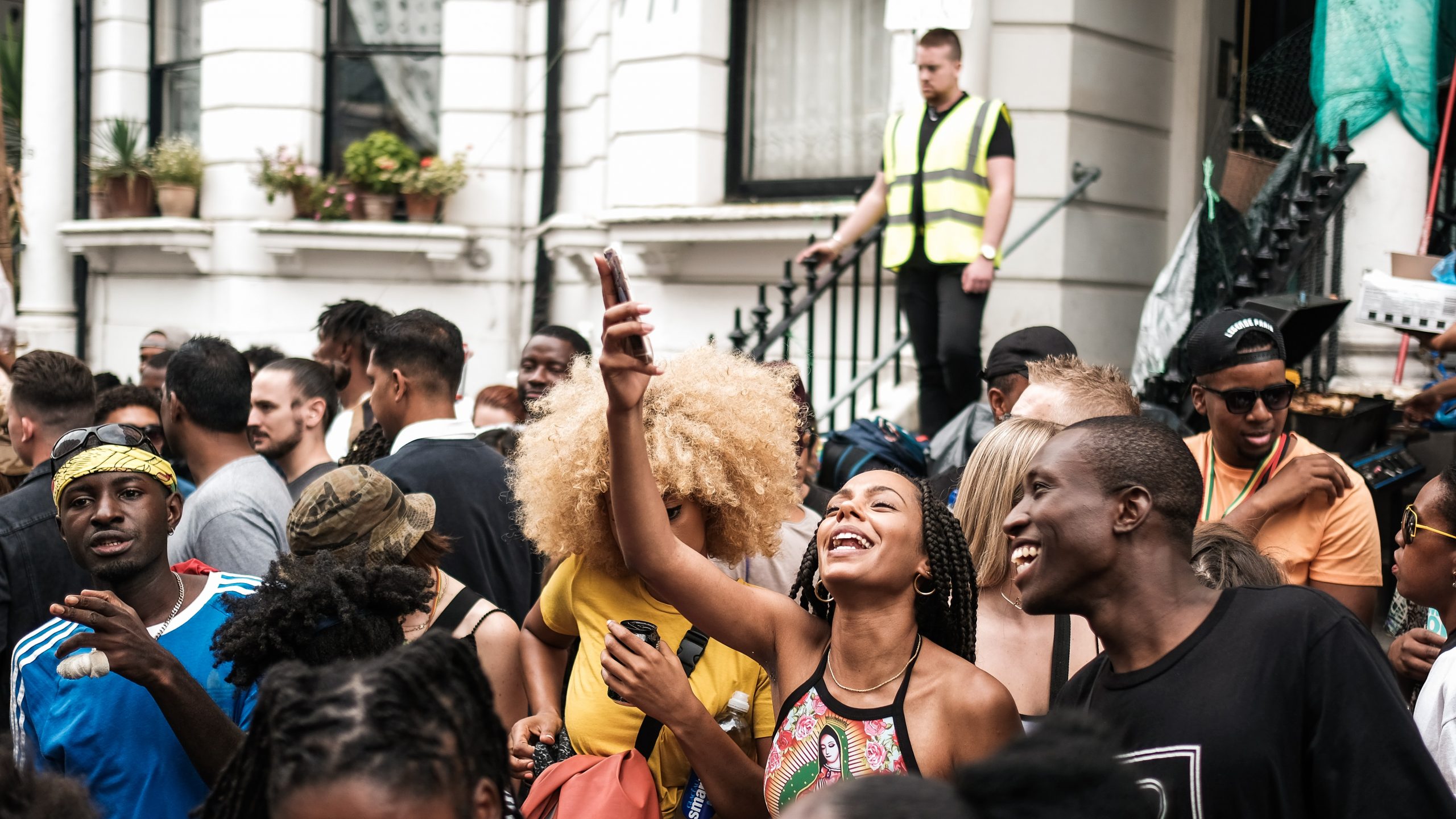 A happy black couple taking a selfie in the middle of the crowds at the Notting Hill Carnival.