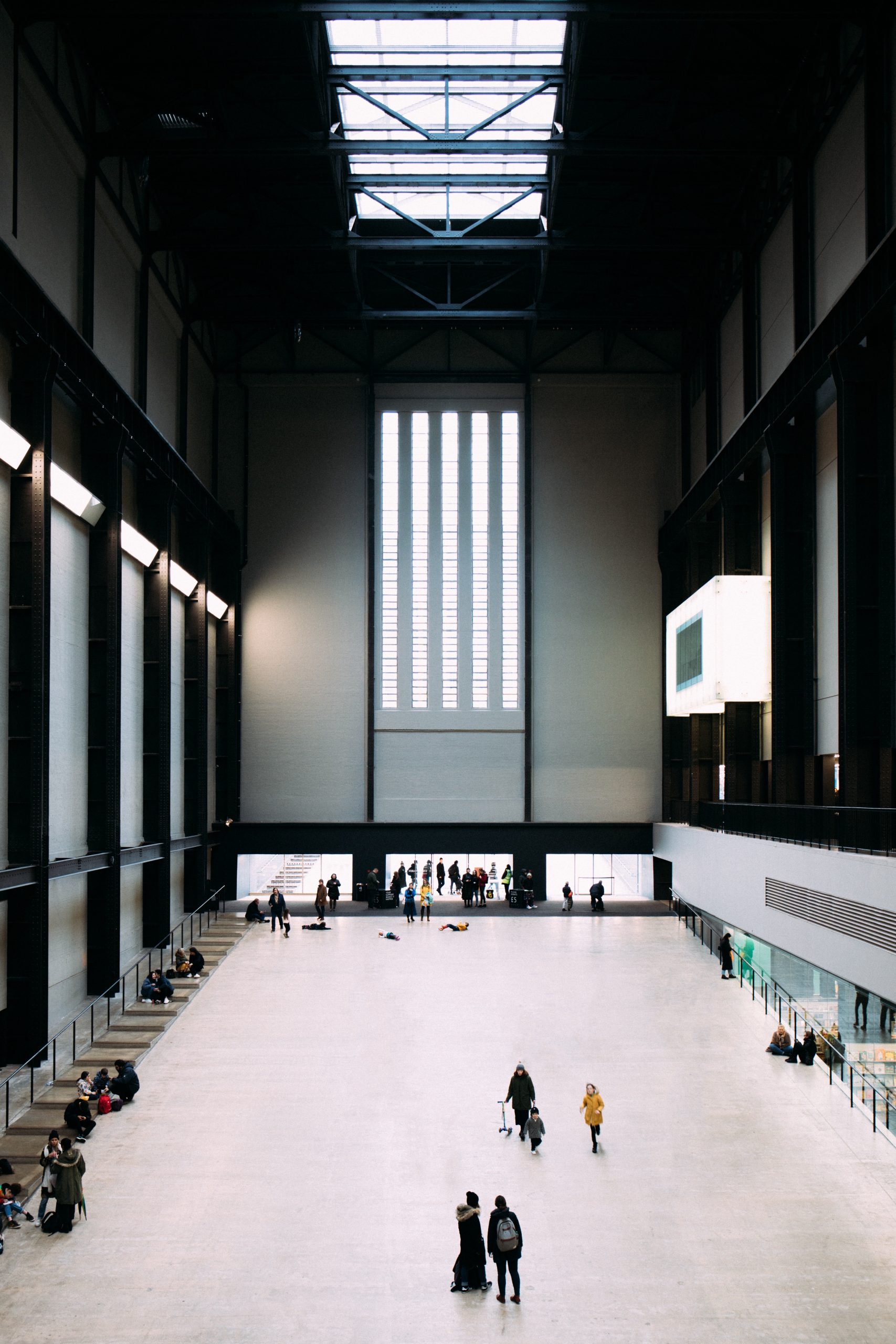 Inside Tate Modern, London, the windows and skylights in the high ceilings fill the hall with light.