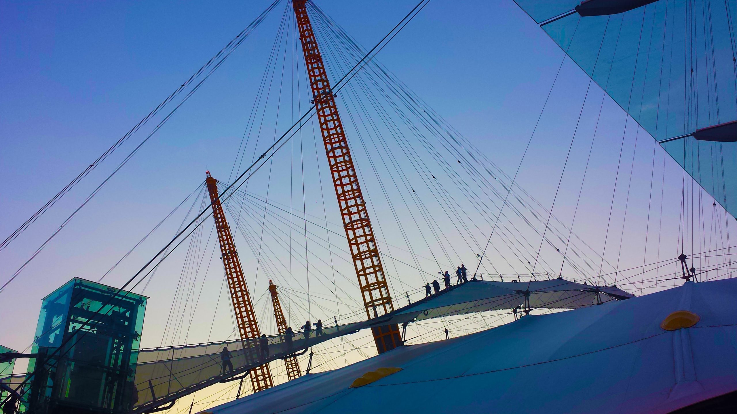 As dusk sets on the O2 Arena dome, several people climb up it to enjoy the view.