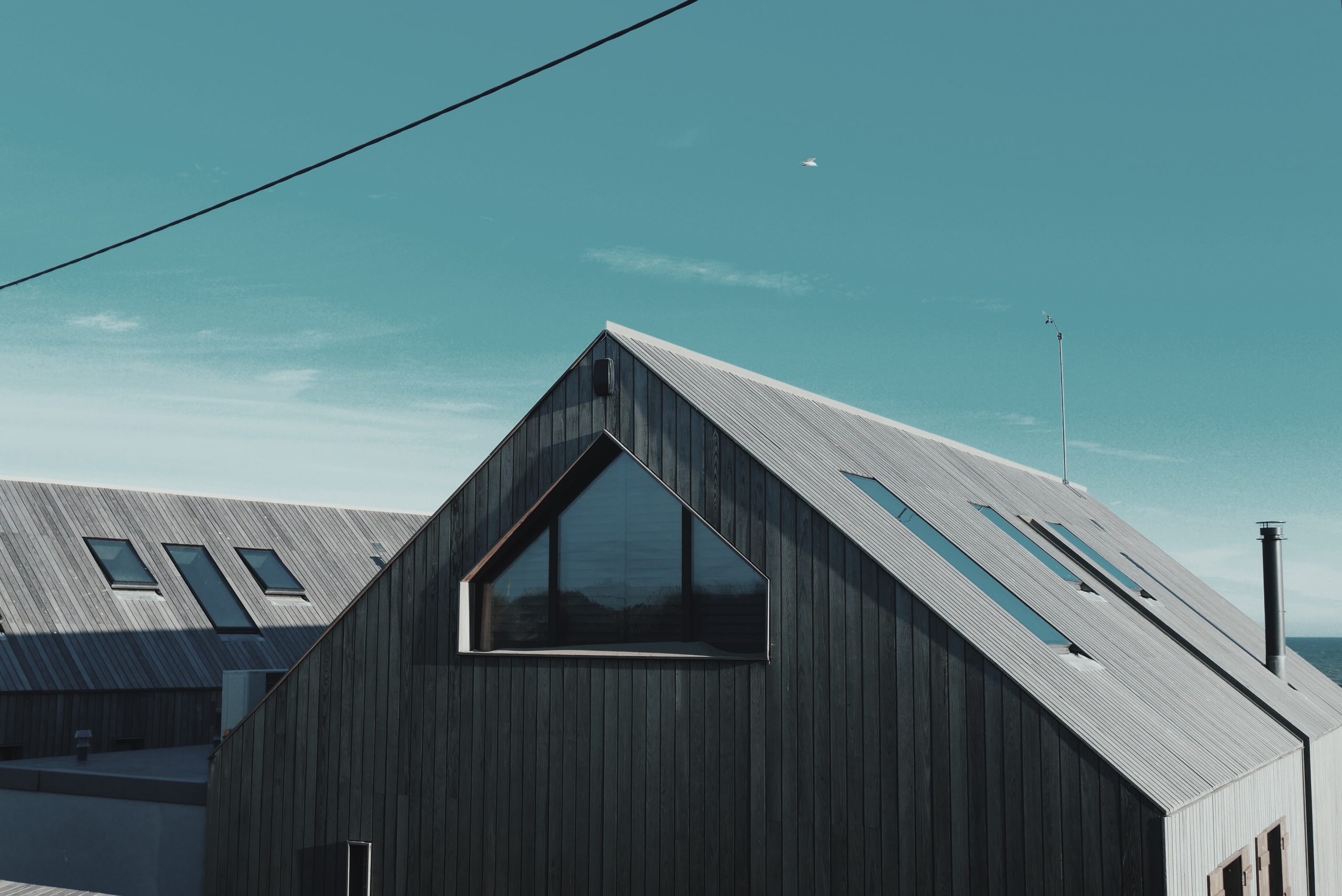 A grey modern barn conversion with skylights on every side.