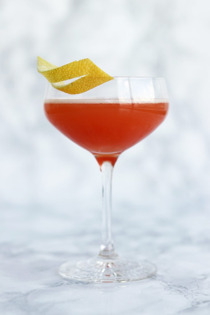 The royal Gin & Dubonnet cocktail framed against a mottled white background.