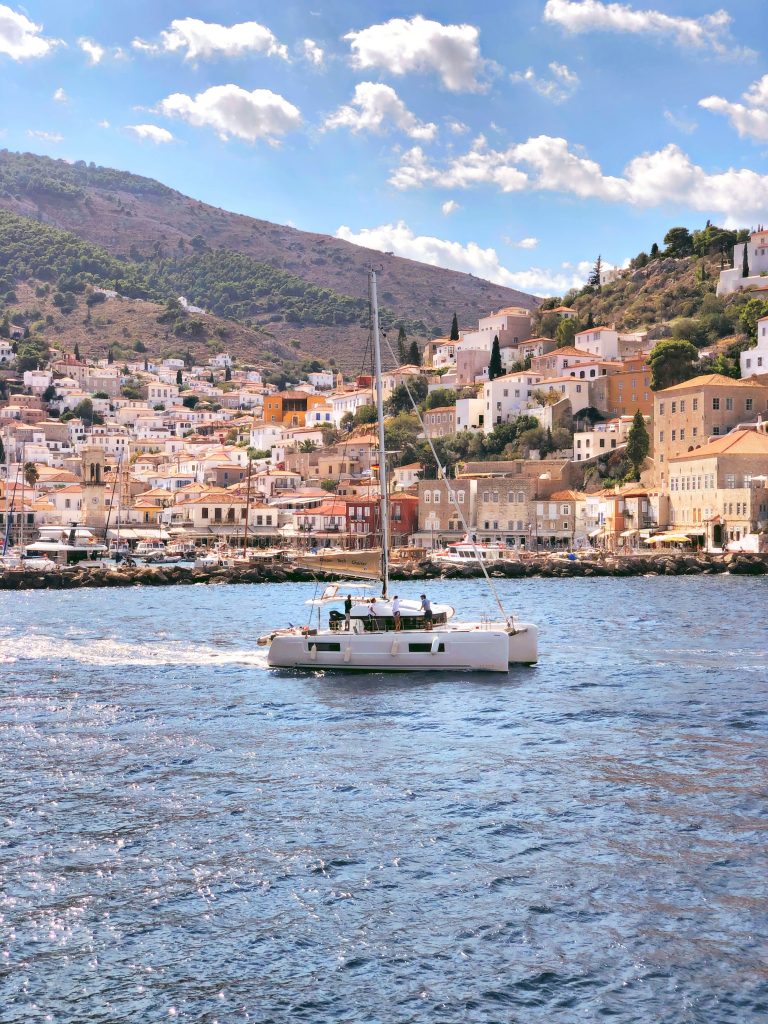 A white boat sailing in to the port of Hydra, Greece.