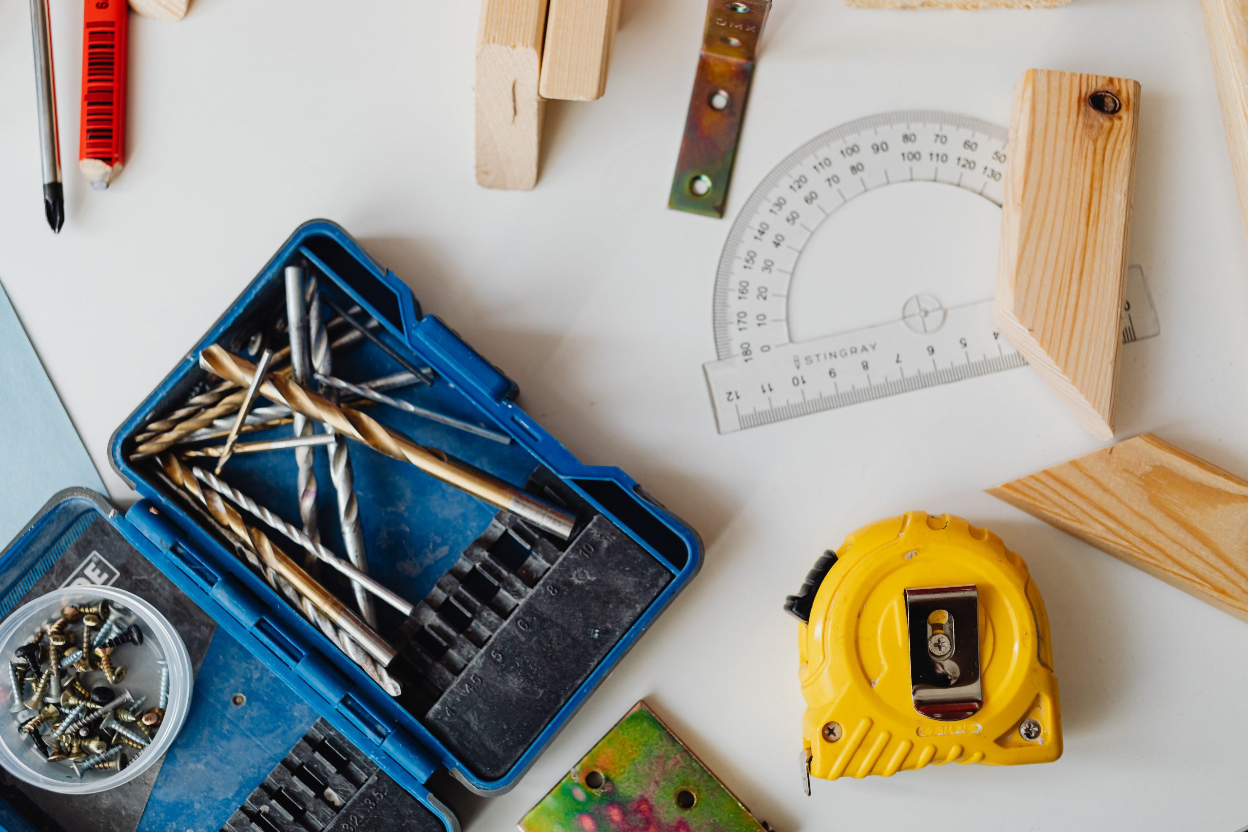 A yellow tape measure with a selection of DIY tools.