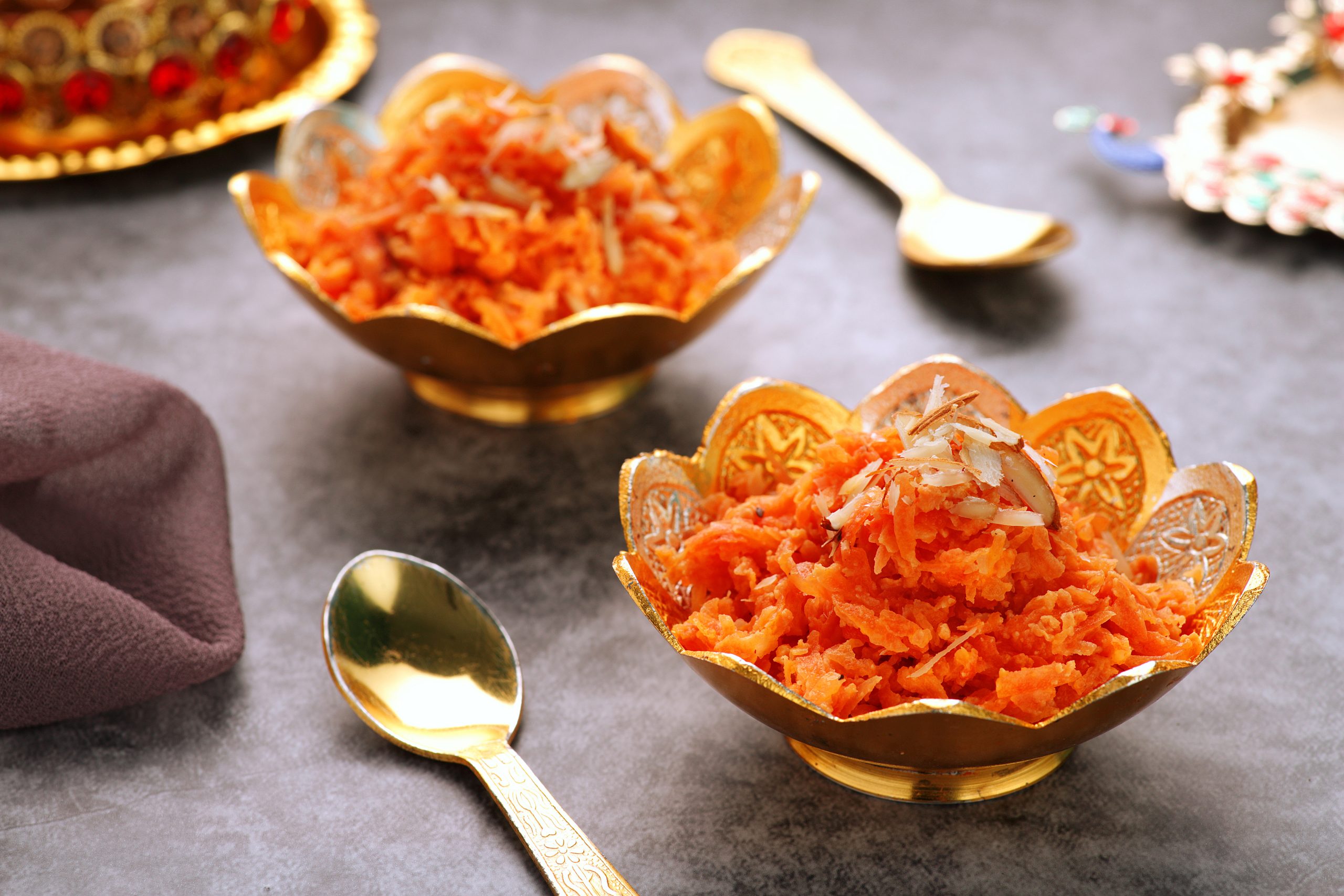 Two servings of the pudding Gajar ka Halwa served in golden bowls.