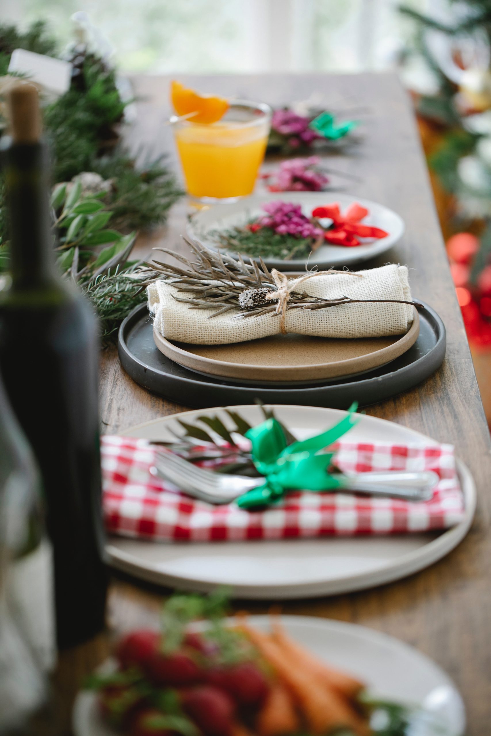 A table set for dinner with plate decorations made up of twigs and greenery.