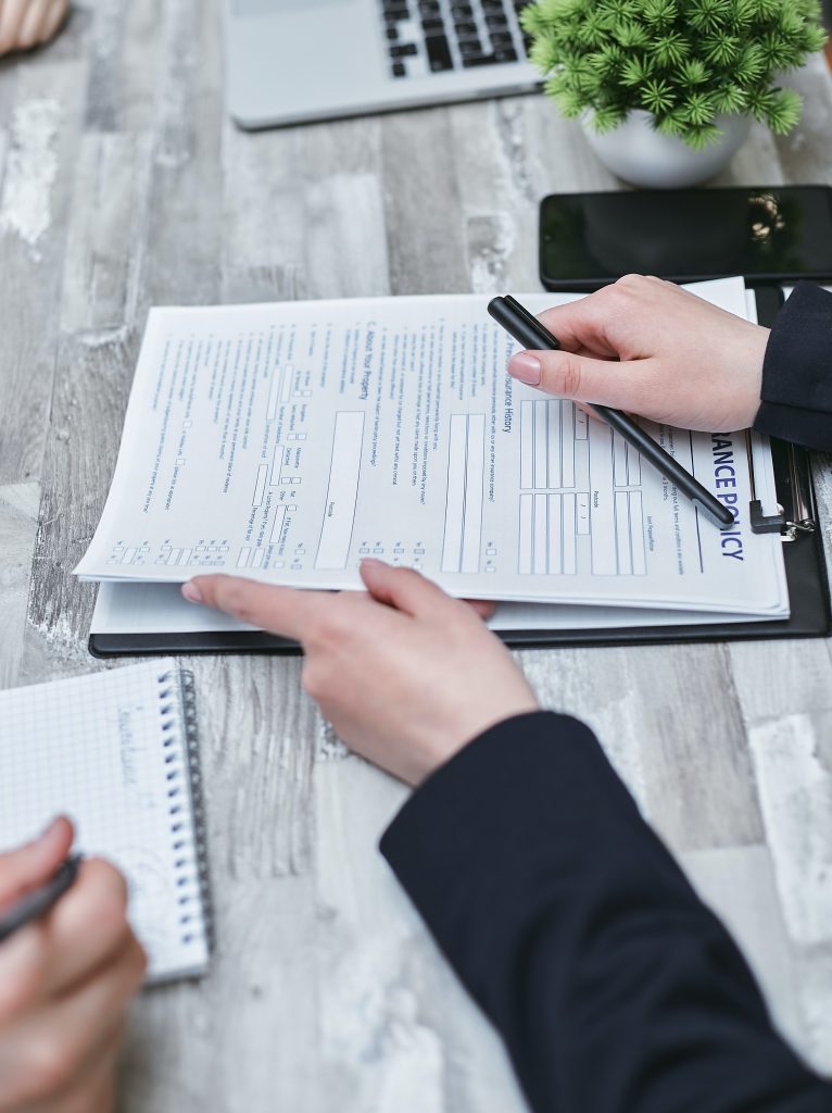 Person holding a document for another person to sign