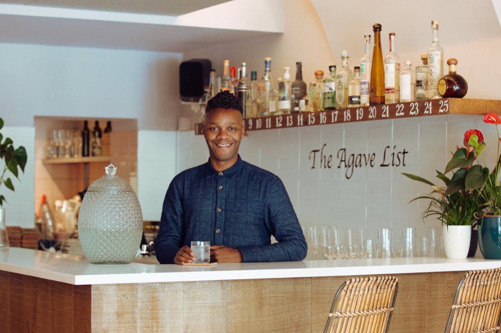 With a smile, bar owner Deano Moncrieffe makes his signature Mirror Margarita cocktail behind a bar.