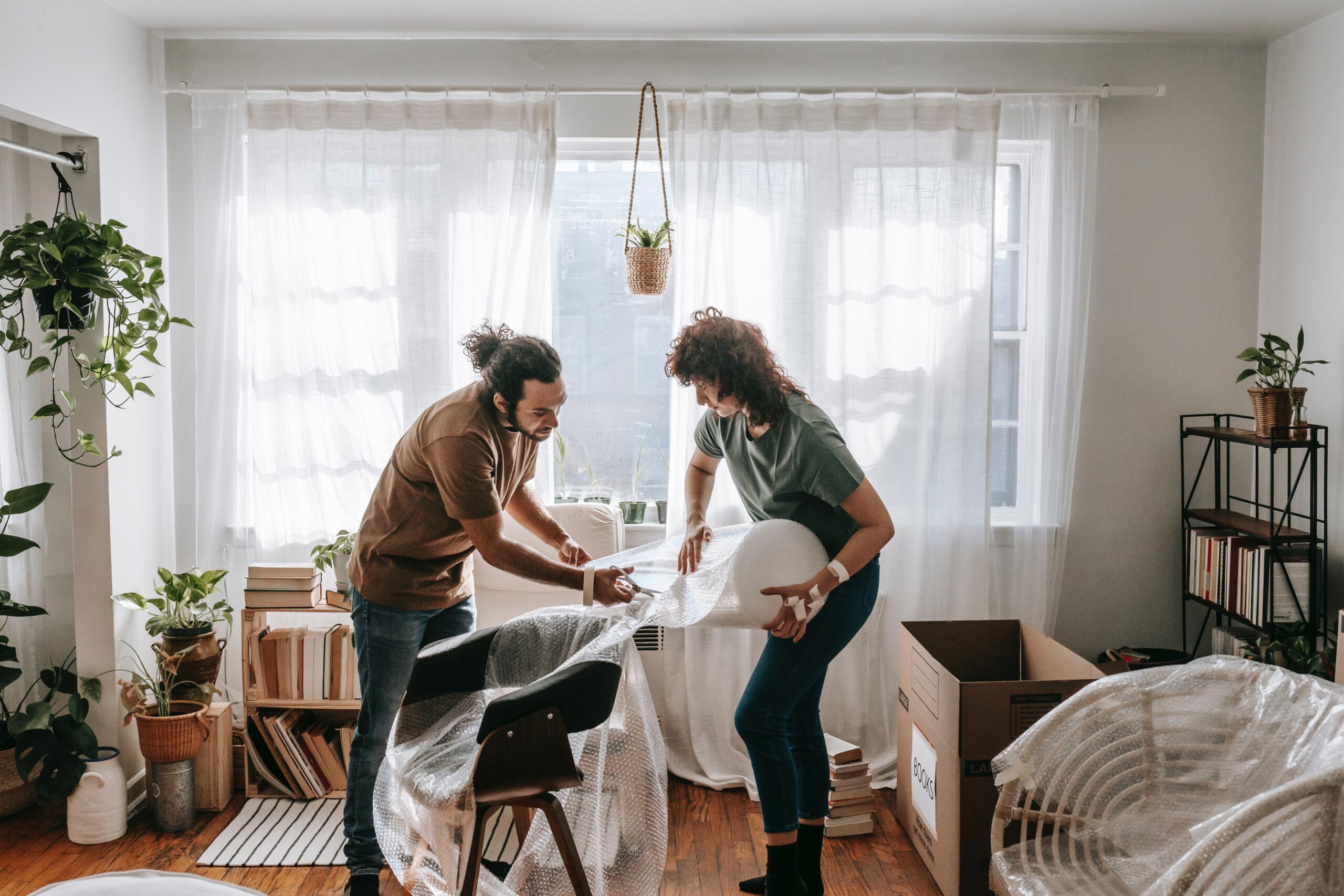 A couple wrapping their spare chairs in bubble wrap to put in storage.