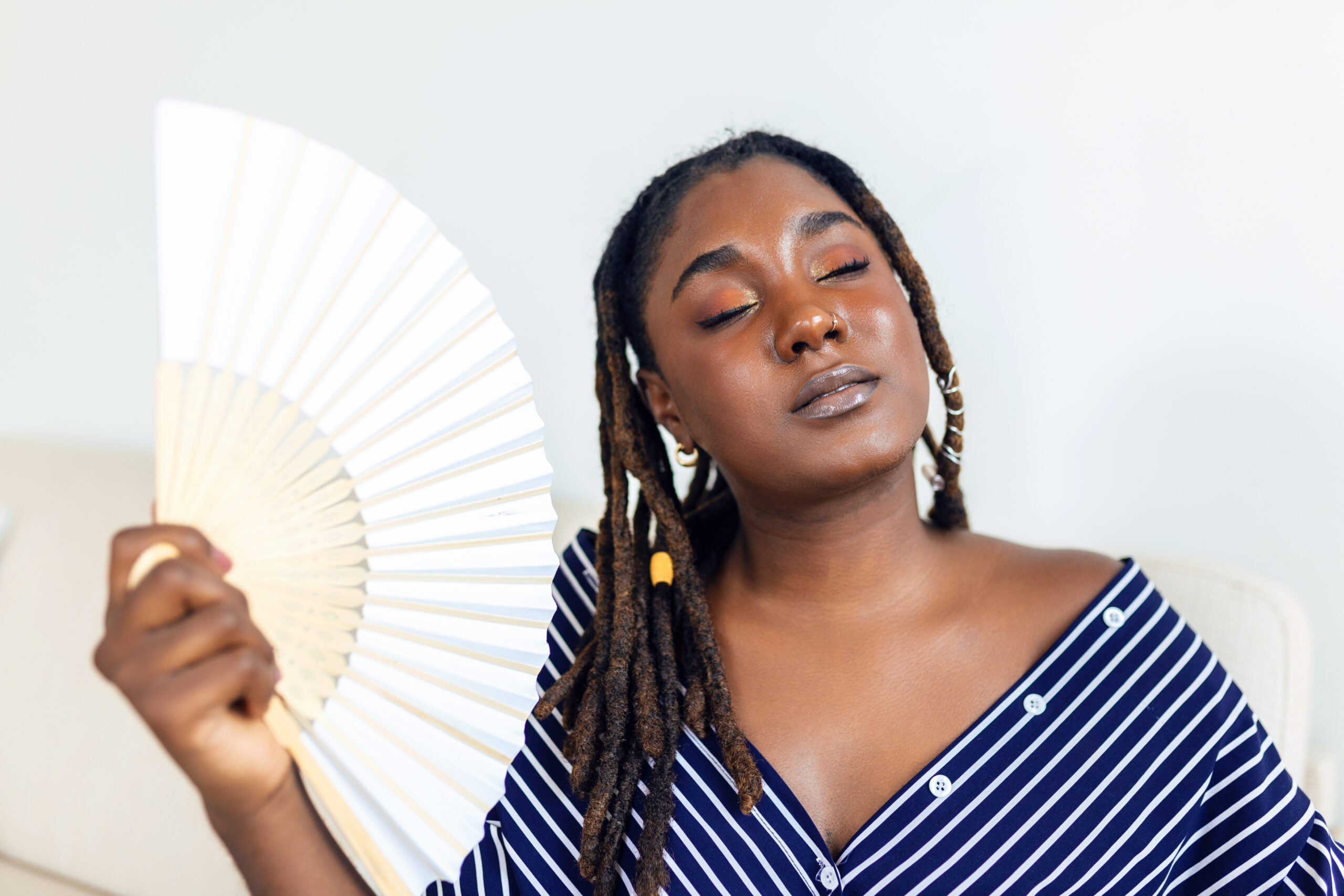 A black woman having a hot flush fans herself