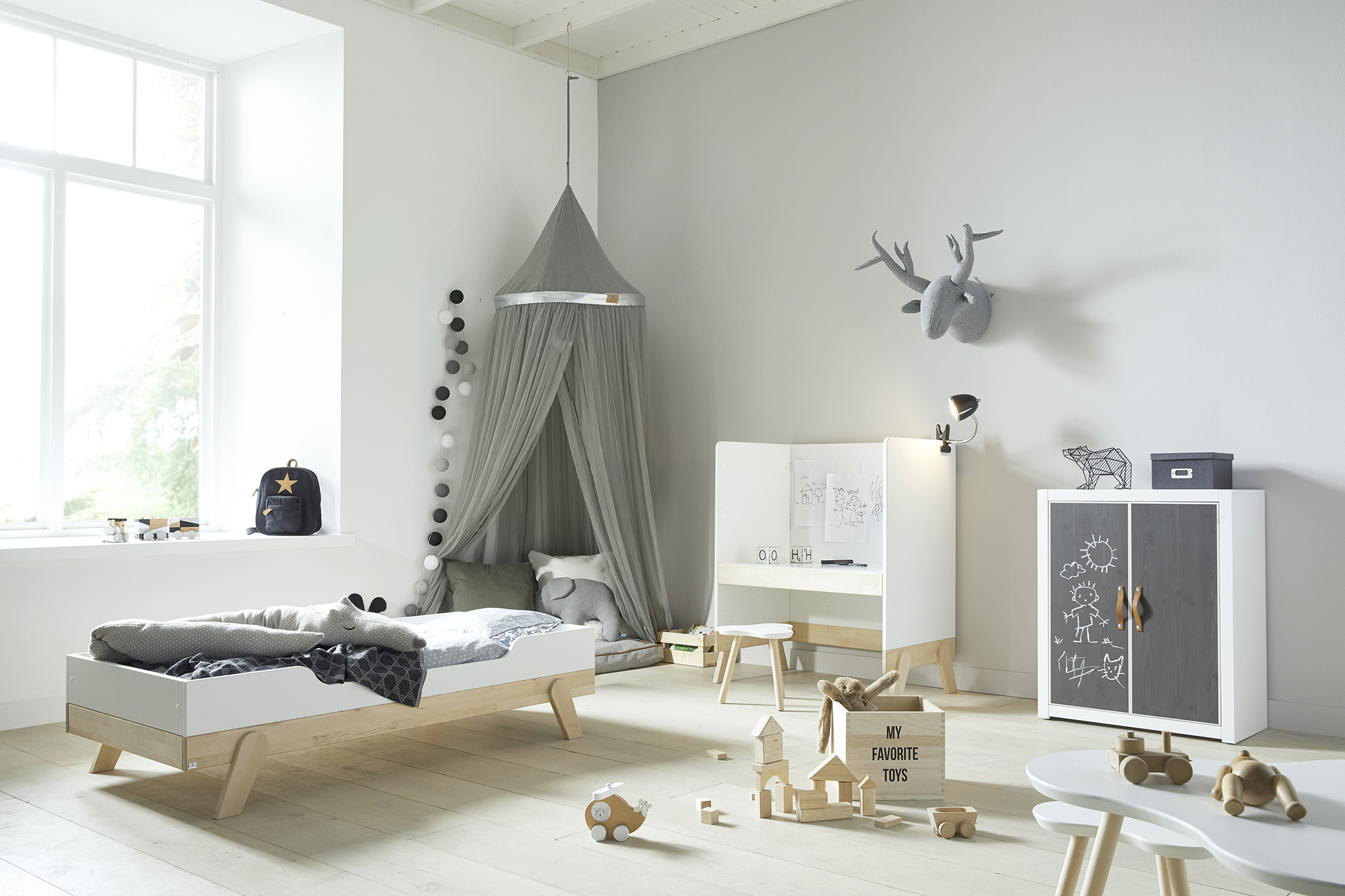 Child's bedroom with bed, toys and desk, in white and grey colours