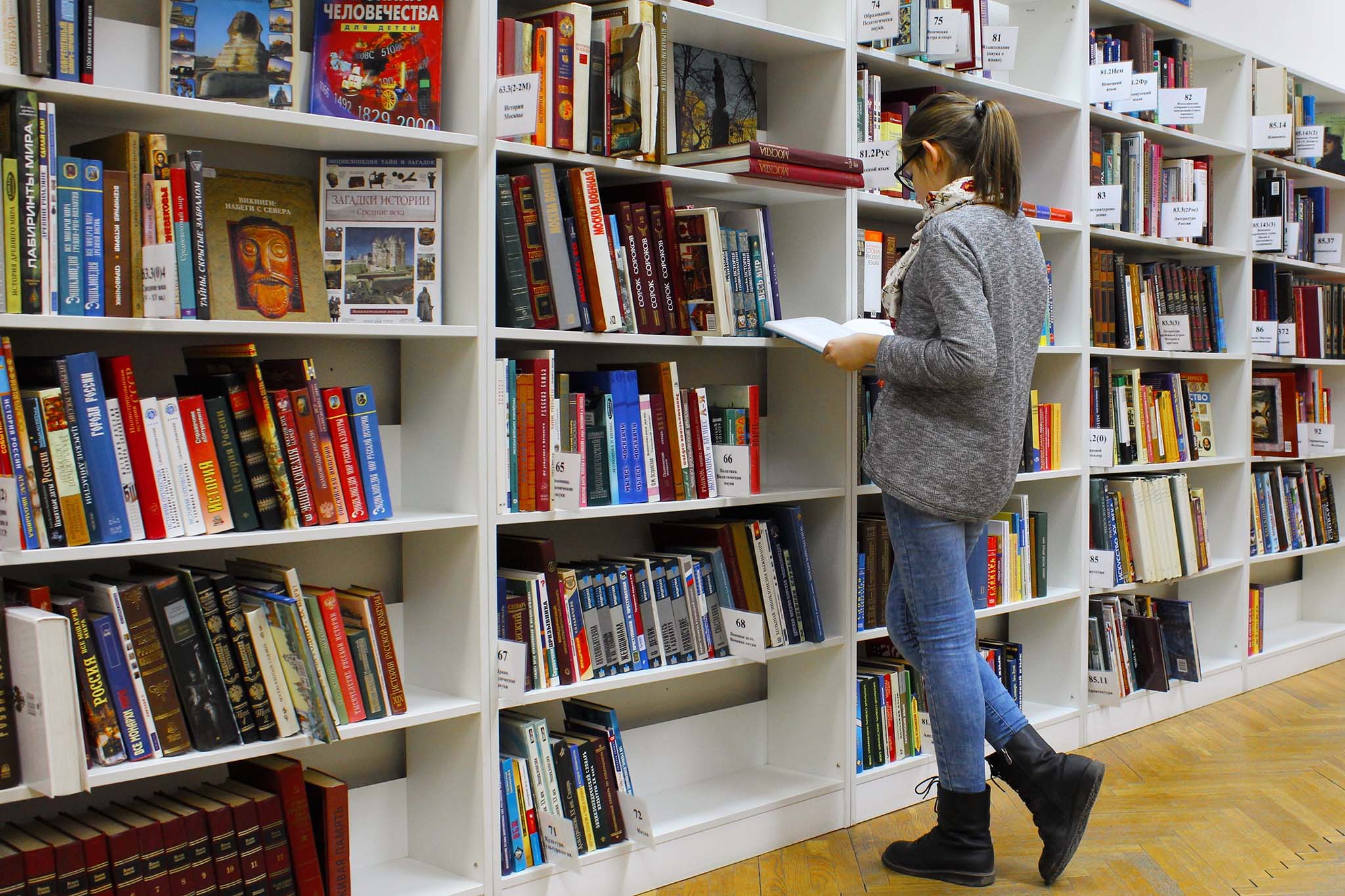 Woman reading book in a library