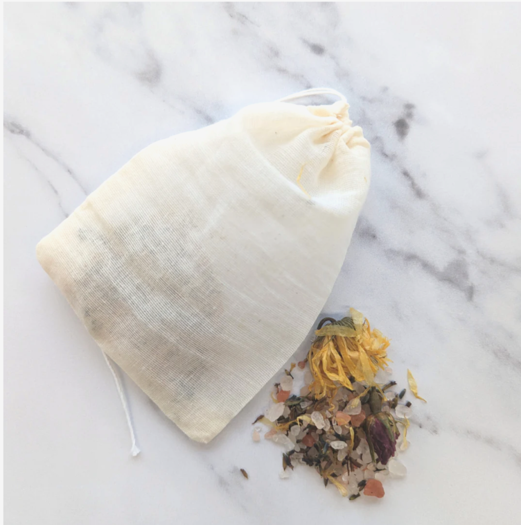 Cotton pouch of Inlight bath soak with petals and salt crystals